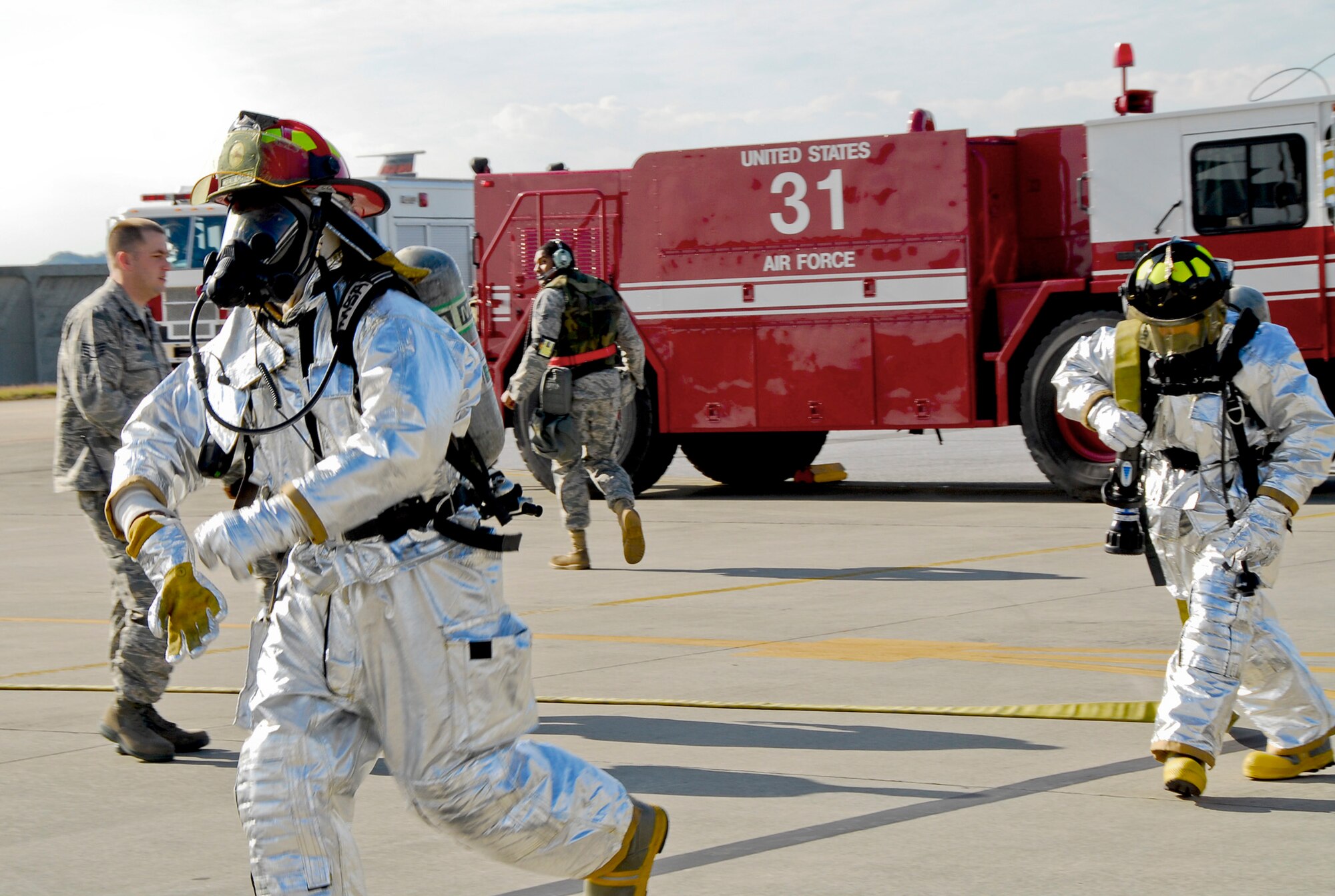 Firefighters from the 18th Civil Engineer Squadron run to save simulated victims in an aircraft-fire scenario during Beverly High 11-02, a local operational readiness exercise Jan. 19, 2011, at Kadena Air Base, Japan. The exercise tested the skills and capabilities of Kadena AB's firefighters, security-forces, and flight-medicine professionals, and their ability to work together during an emergency. (U.S. Air Force photo/Airman 1st Class Maeson L. Elleman)