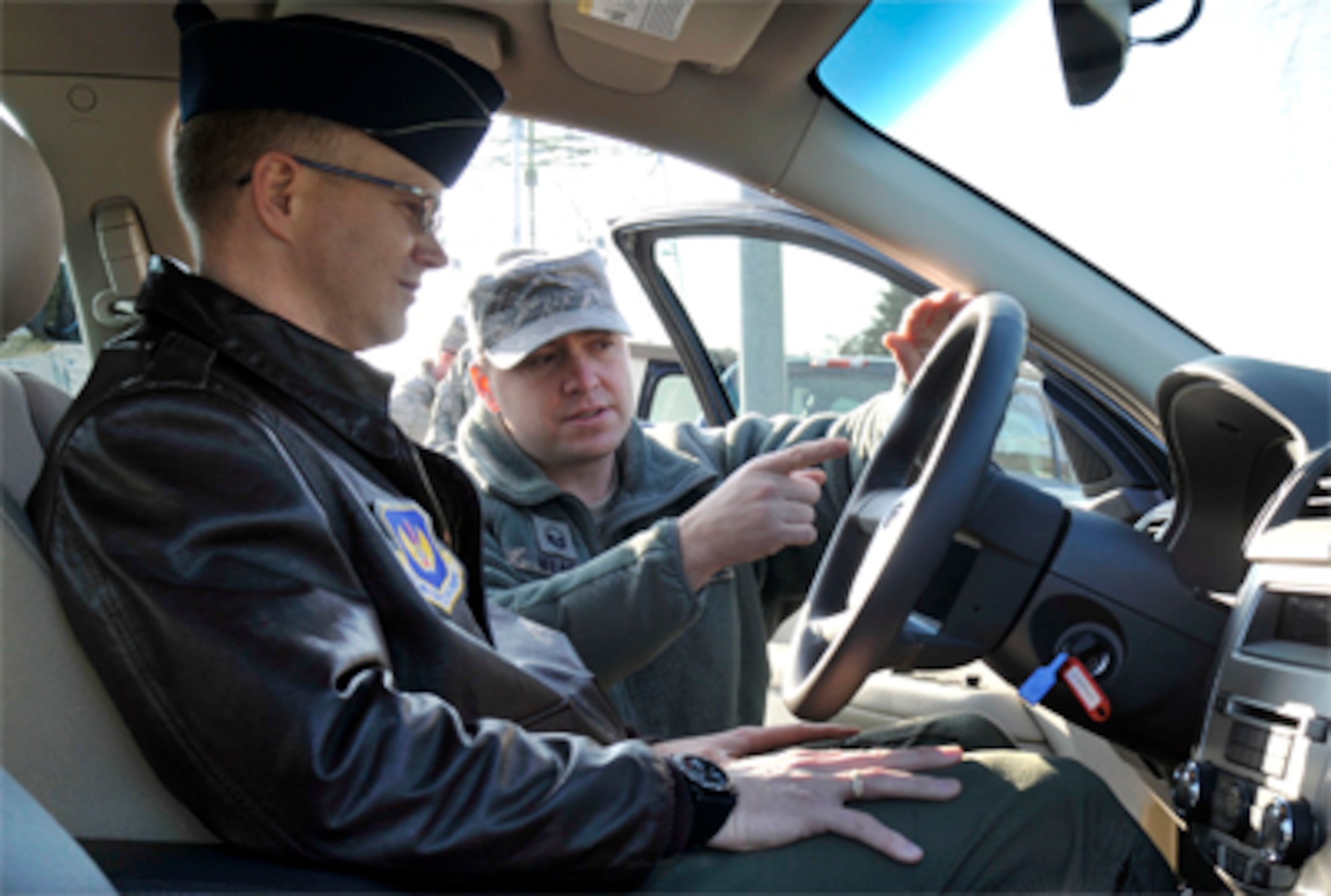 Master Sgt. Kevin Mead instructs Col. Christopher Weggemen on the proper use of his new hybrid vehicle Jan. 21, 2011, at Spangdahlem Air Base, Germany. Colonel Weggemen is the first person to drive a hybrid in the fleet at Spangdahlem AB, as a step toward the goal to comply with an executive order requiring a 34 percent reduction in greenhouse gas emissions by 2020 and 20 percent reduction of petroleum use by 2015. Sergeant Mead is a European Transportation Training Center instructor and Colonel Weggemen is the 52nd Fighter Wing commander. (U.S. Air Force photo/Airman 1st Class Brittney Frees)
