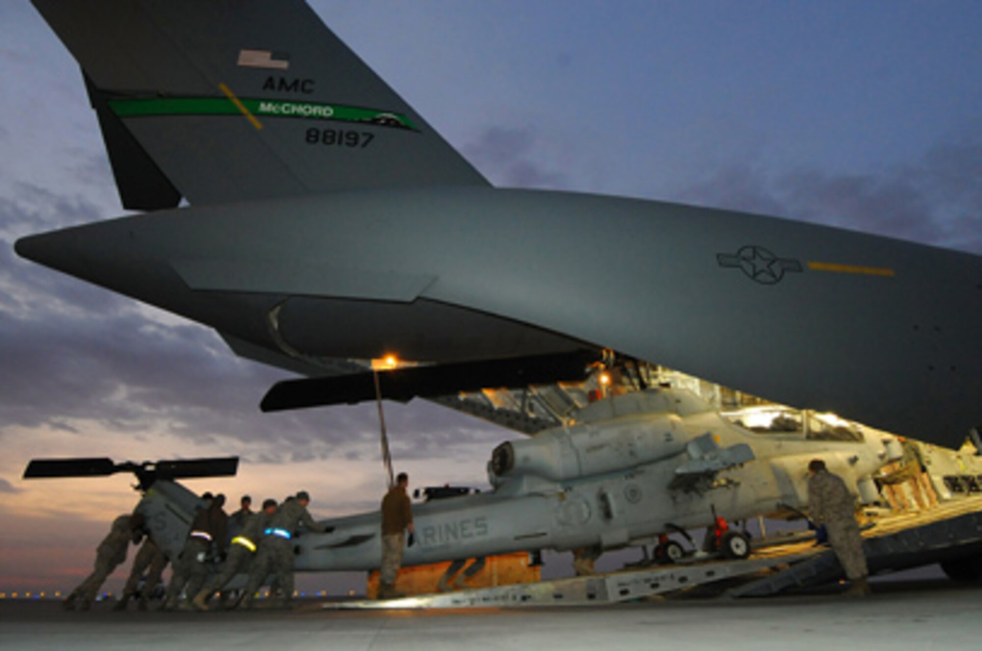 Airmen, Marines and Sailors work together to load an AH-1 Whiskey Super Cobra on a C-17 Globemaster III recently in Southwest Asia. Airmen with the 386th Expeditionary Readiness Squadron and loadmasters with the 817th Expeditionary Airlift Squadron worked with Marines and Sailors of the 26th Marine Expeditionary Unit to get their cargo to a forward location. (U.S. Air Force photo/Senior Airman Cynthia Spalding) 