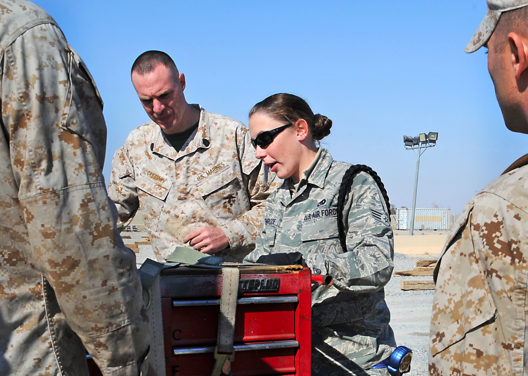 Senior Airman Chelsea Eckenrode helps ensure that Marines from the 26th Marine Expeditionary Unit have the proper guidence while they strap down their cargo and prep for inspection recently in Southwest Asia. More than 1,300 Marines and Sailors and 370,000 pounds of cargo were transported to a forward location with the help of Airmen from the 386th Expeditionary Logistics Readiness Squadron. Airman Eckenrode is a hazardous material joint-inspector assigned to the 386th ELRS. (U.S. Air Force photo/Senior Airman Cynthia Spalding)