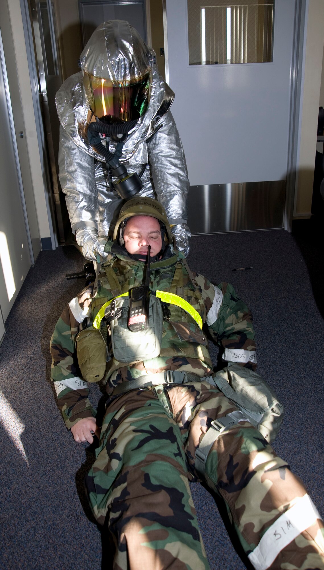 A U.S. Air Force 35th Civil Engineer Squadron Airman drags an Airman to safety in response to a simulated missile attack at building 1173, Misawa Air Base, Japan, Jan. 25, 2011. The response was part of an operational readiness exercise, which tests Airmen's ability to survive and operate during contingency operations.  (U.S. Air Force photo by Tech. Sgt. Russell McBride/Released)