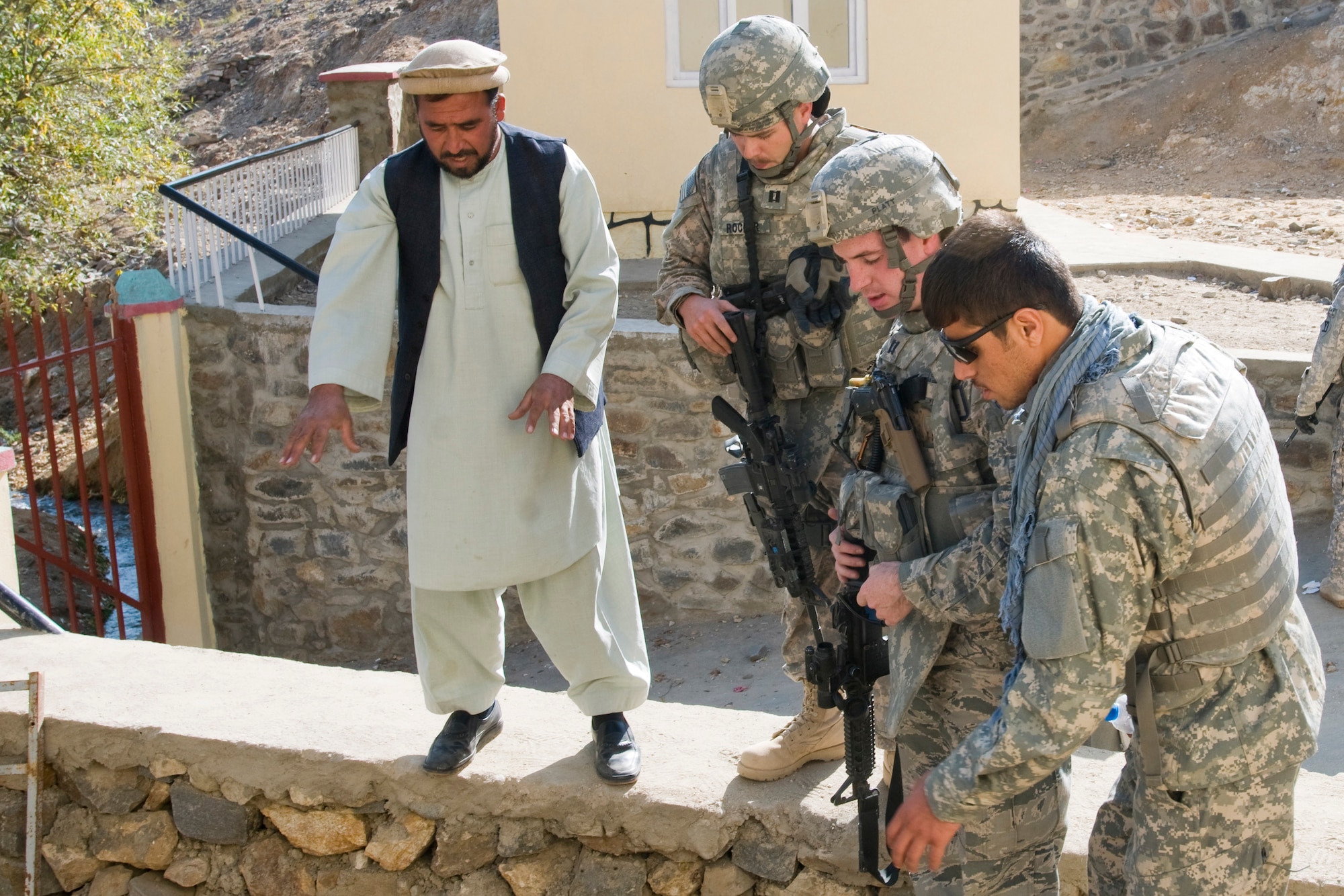 KAPISA PROVINCE, Afghanistan -- Engineers for Kapisa Provincial Reconstruction Team, U.S. Air Force Capts. Brandon Rocker and Seth Platt discuss the status of a well with a local contractor representative at the Abdual Manan school during a quality control inspection in Nijrab, Afghanistan Nov. 13, 2010. The school is nearing completion and will accommodate approximately 800 to 900 Afghan children per year once open. (U.S. Air Force photo/Staff Sgt. Kyle Brasier)