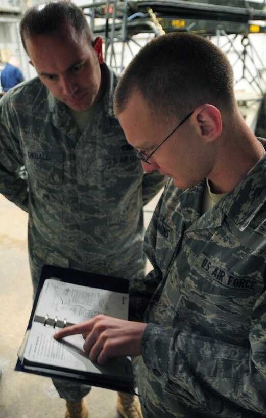 (Right to left) Airman 1st Class Christian Mains, 28th Aircraft Maintenance Squadron able chief, goes over technical orders with Staff Sgt. Chris Dieball, 28th AXMS crew chief instructor, at Ellsworth Air Force Base, S.D., Jan. 21.  Knowing how to read and understand a TO is crucial when dealing with the multi-million dollar B-1B Lancer. (U.S. Air Force photo/Senior Airman Anthony Sanchelli)