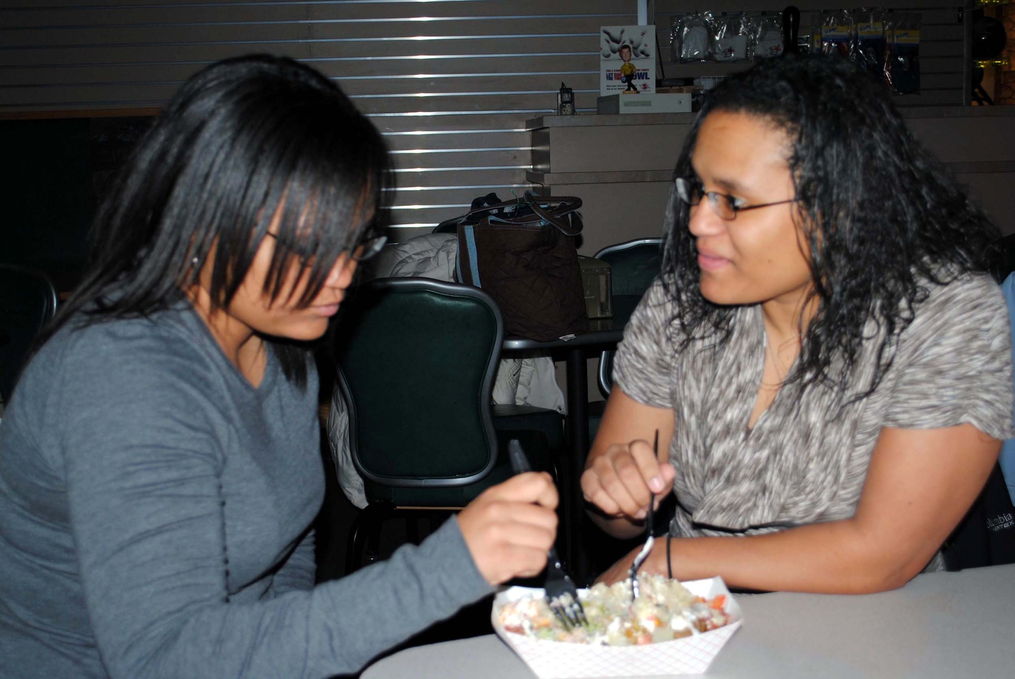 Senior Airman Tambara Hamilton, a 341st Medical Support Squadron lab technician (left), and Senior Airman Shaleena Pulliam, a 341st Medical Operations Squadron dental assistant, share a salad for dinner.  Outside of their work they spend all the time they can together. (U.S. Air Force photo/Airman Cortney Hansen)