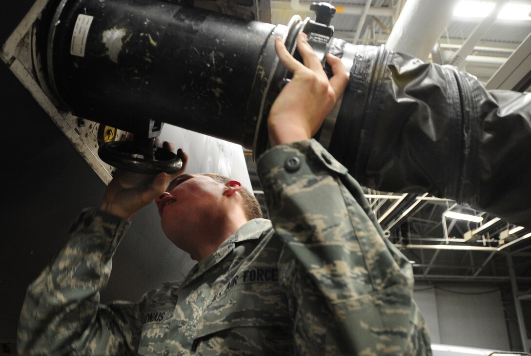 Airman Mark Vadnais, 28th Aircraft Maintenance Squadron able chief, attaches an airflow hose to a B-1B Lancer at Ellsworth Air Force Base, S.D., Jan. 21.  The airflow hose is used to cool off electrical systems during maintenance of the B-1. (U.S. Air Force photo/Senior Airman Anthony Sanchelli)