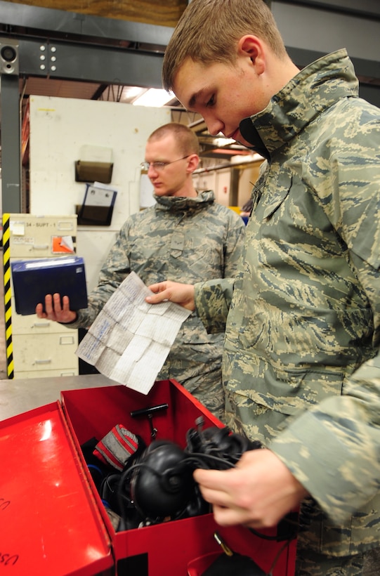 (Right to left) Airman Mark Vadnais and Airman 1st Class Christian Mains, 28th Aircraft Maintenance Squadron able chiefs, sign out tools and technical orders from the 28th AMXS maintenance shop at Ellsworth Air Force Base, S.D., Jan. 21.  Both Airmen are undergoing on-the-job training to maintain the B-1B Lancer. (U.S. Air Force photo/Senior Airman Anthony Sanchelli)