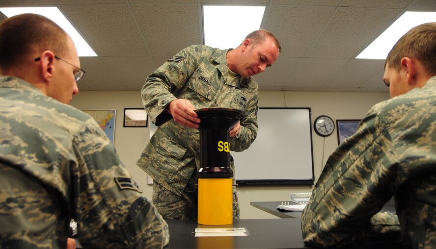 (Left to right) Airman 1st Class Christian Mains and Airman Basic Mark Vadnais, 28th Aircraft Maintenance Squadron able chiefs, learn the proper procedures to connect an airflow hose attachment to a B-1B Lancer from Staff Sgt. Chris Dieball, 28th AMXS crew chief instructor, at Ellsworth Air Force Base, S.D., Jan. 21.  B-1 able chief Airmen must attend 22 academic days, consisting of 108 hours of training, before becoming a true crew chief. (U.S. Air Force photo/Senior Airman Anthony Sanchelli)