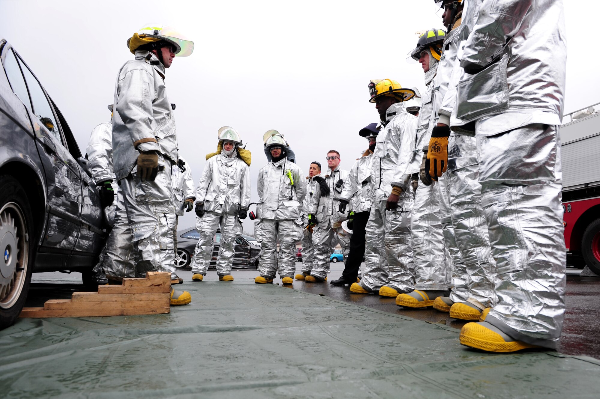 U.S. Army Soldiers from the 18th Combat Support Sustainment Regiment's 23rd Ordinance Company, and Air Force Airmen from the 886th Civil Engineer Squadron receive a safety briefing before disassembling a vehicle, Kapaun Air Station, Germany, Jan. 25, 2011. The soldiers are on a three-week tour to working side-by-side airmen to gain a better understanding on how Air Force firefighters operate. (U.S. Air Force photo by Airman 1st Class Brea Miller)