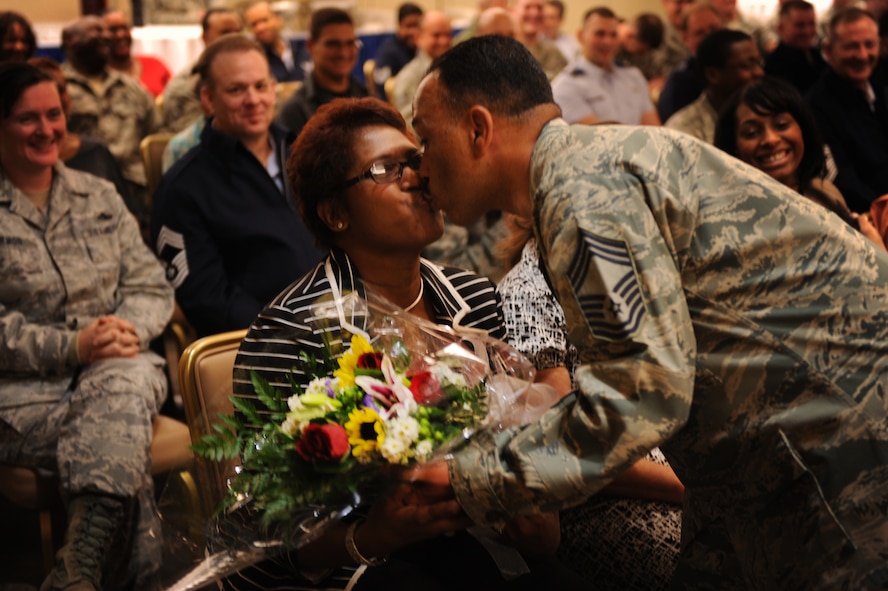 MOODY AIR FORCE BASE, Ga. -- Chief Master Sgt. Alejandro DePass, 723rd Aircraft Maintenance Squadron superintendent, kisses his wife, Telma DePass, during his retirement ceremony Jan. 25. Chief DePass also gave flowers to his wife, his sister and his daughter. (U.S. Air Force photo/Airman 1st Class Douglas Ellis)(RELEASED)
