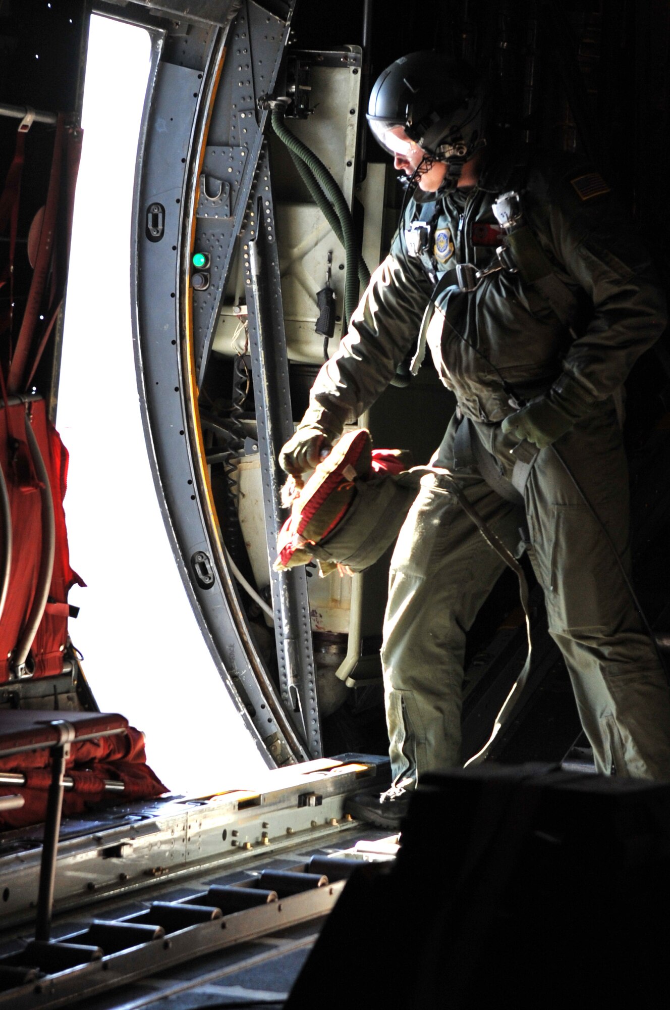 Tech Sgt. Josh Taylor, 50th Airlift Squadron loadmaster instructor, prepares to throw a 15 lbs. training bundle out the side door of a C-130 Jan. 13, 2011, during the First Term Airman’s Center incentive Flight. The incentive flight gives Team Little Rock’s newest Airmen a closer look at the bases C-130 Combat Airlift mission. (U.S. Air Force photo By Airman 1st Class Rusty Frank)