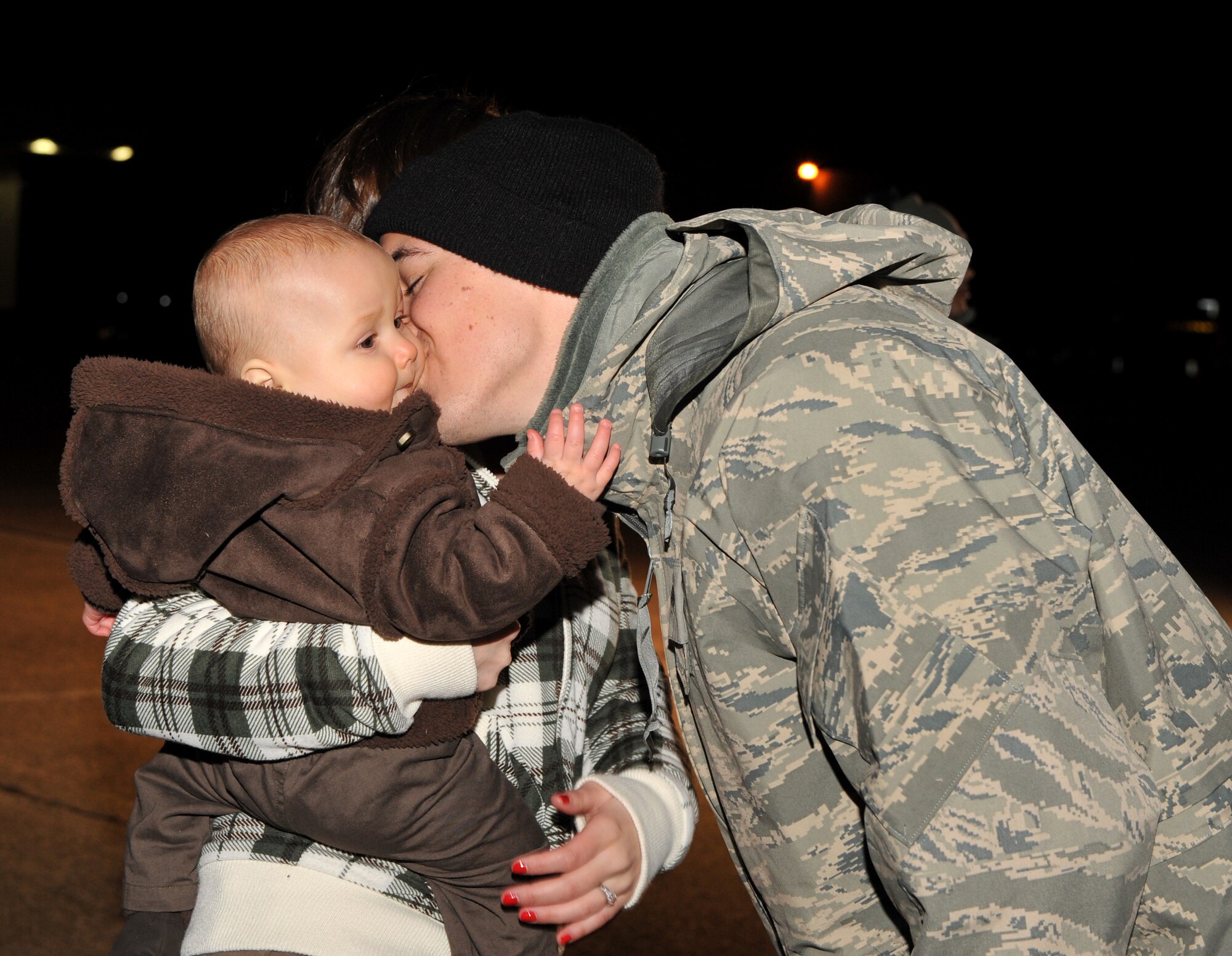 Senior Airman Adam Conrad, 61st Airlift Squadron flight engineer, kisses his son, Quinn, 8 months-old, after returning from his deployment Jan. 22, 2011, at Little Rock Air Force Base, Ark. The Airmen returned from deployment after spending more than 155 days in Ali Al Salem Air Base, Kuwait. (U.S. Air Force photo by Senior Airman Gul Crockett)