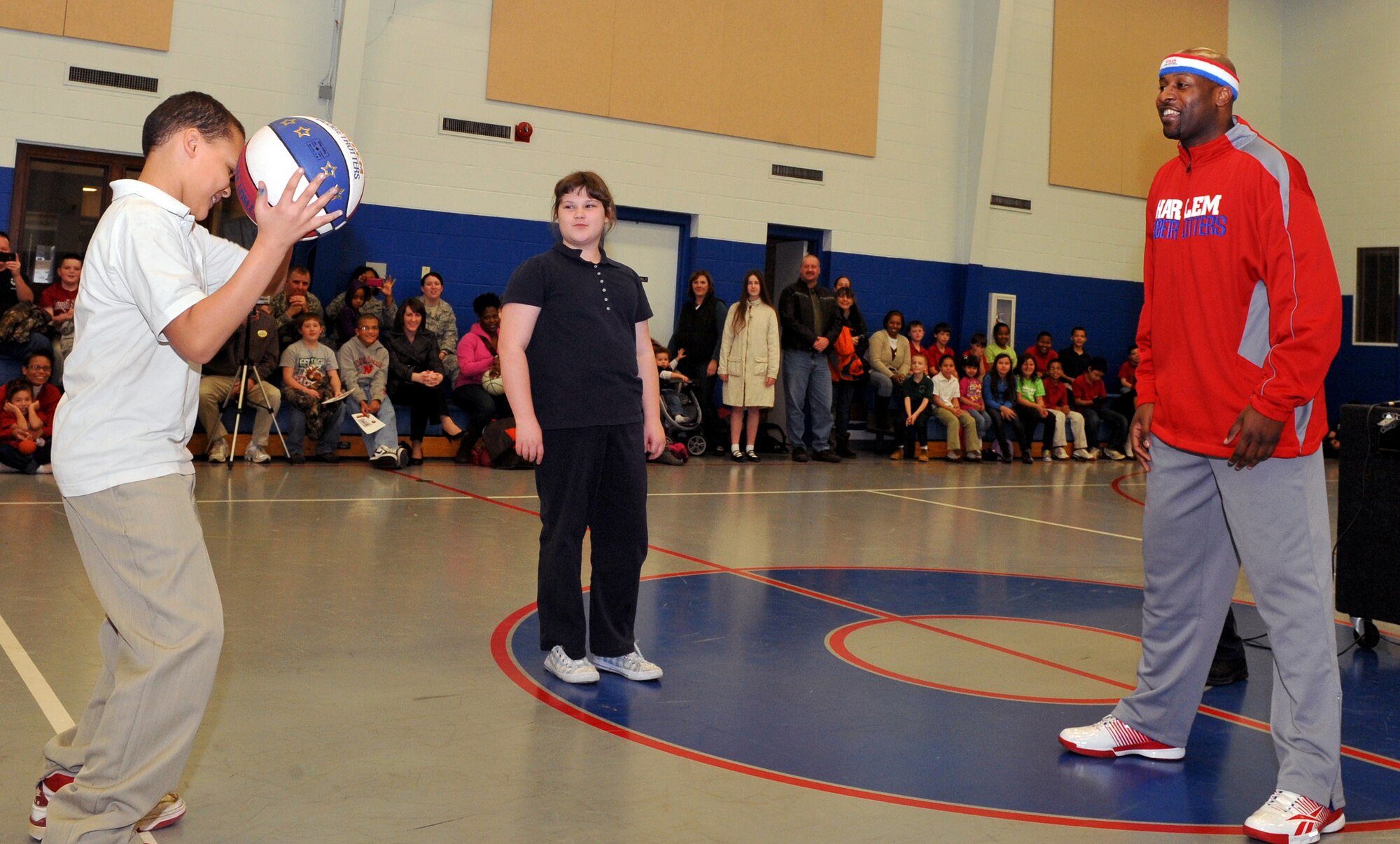Harlem Globetrotter Aundre “Hot Shot” Branch teaches a basketball trick to Michael Mitchell, 11, at the Youth Center at Little Rock Air Force Base, Ark., Jan. 21, 2011. Hot Shot came to Little Rock to tell the children about the Harlem Globetrotters, reach out to his fans and show his appreciation to the families of the military community. (U.S. Air Force photo by Senior Airman Gul Crockett)