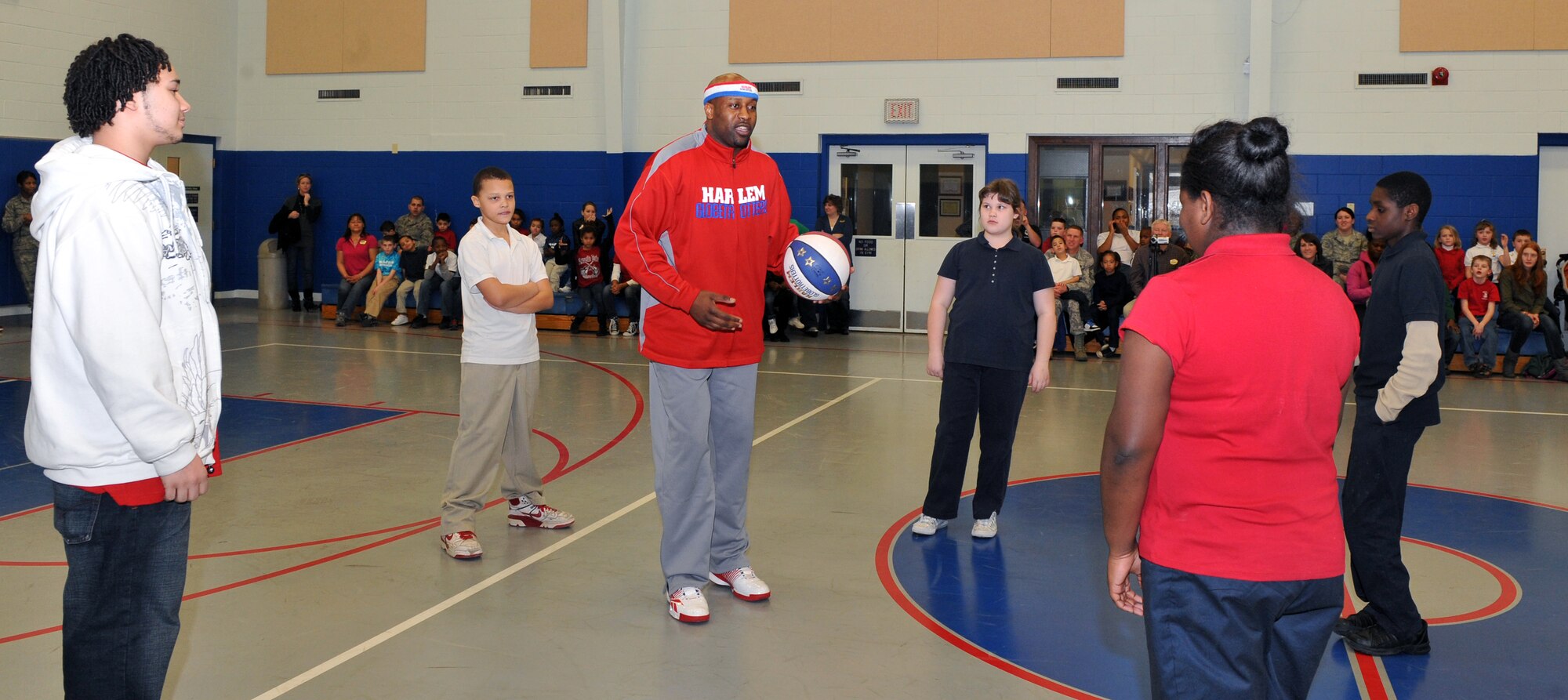 Harlem Globetrotter Aundre “Hot Shot” Branch demonstrates to the kids at the Youth Center at Little Rock Air Force Base, Ark. Jan. 21, 2011. Hot Shot talked to the kids about “C.H.E.E.R. for Character”, that concentrates on Cooperation, Healthy mind and body, Effort, Enthusiasm, and Responsibility. (U.S. Air Force photo by Senior Airman Gul Crockett)
