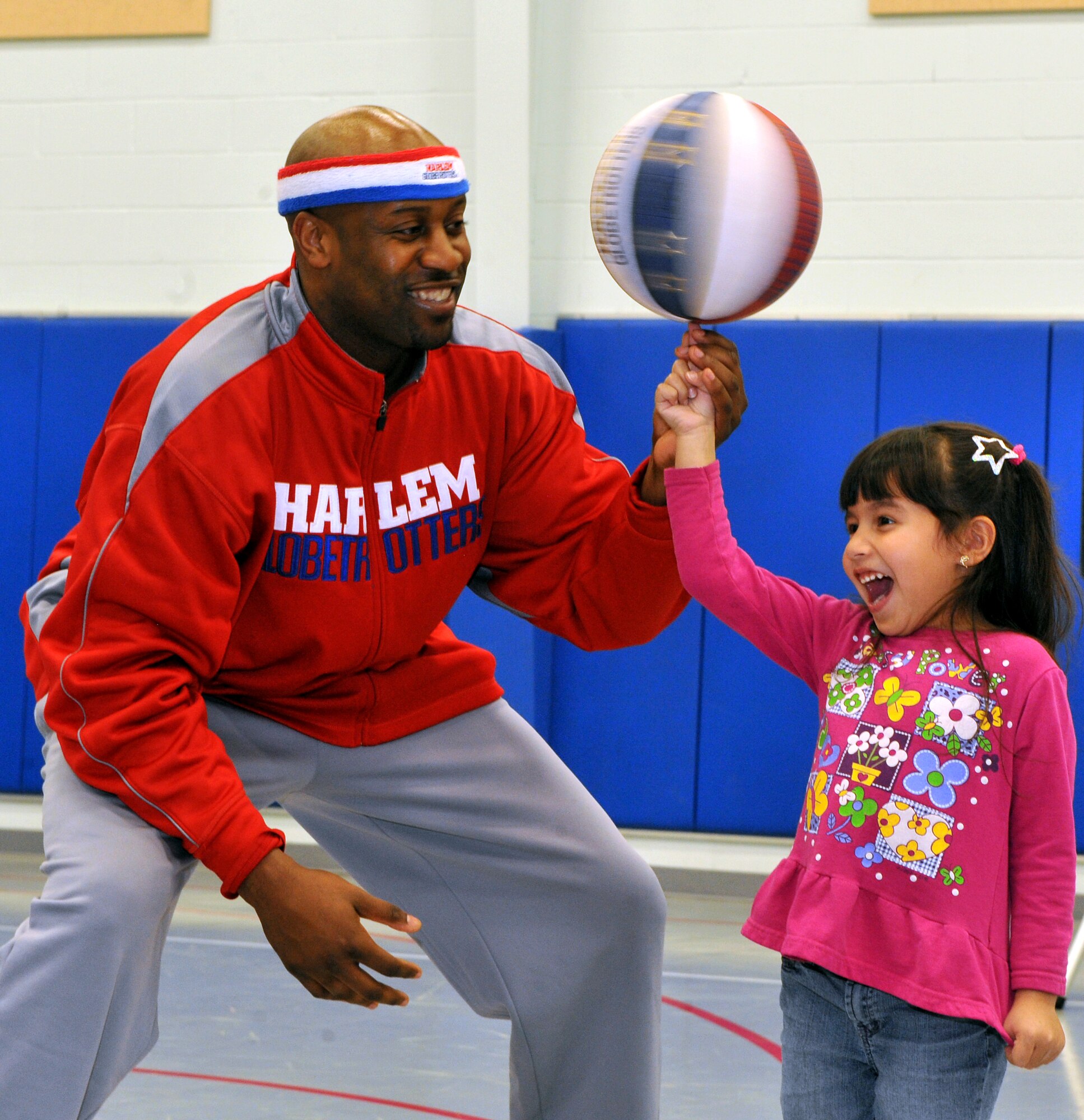 Harlem Globetrotter Aundre “Hot Shot” Branch spins a basketball on the finger of Andrea Galloway, daughter of Master Sgt.  Randall Galloway, a 19th Logistic Readiness Squadron fuels section chief, at the Youth Center on Jan. 21, 2011, at Little Rock Air Force Base.  Hot Shot provided a basketball demonstration for the children and focused on Cooperation, Healthy mind and body, Effort, Enthusiasm, and Responsibility, also known as “C.H.E.E.R. for Character." (U.S. Air Force photo by Senior Airman Gul Crockett)