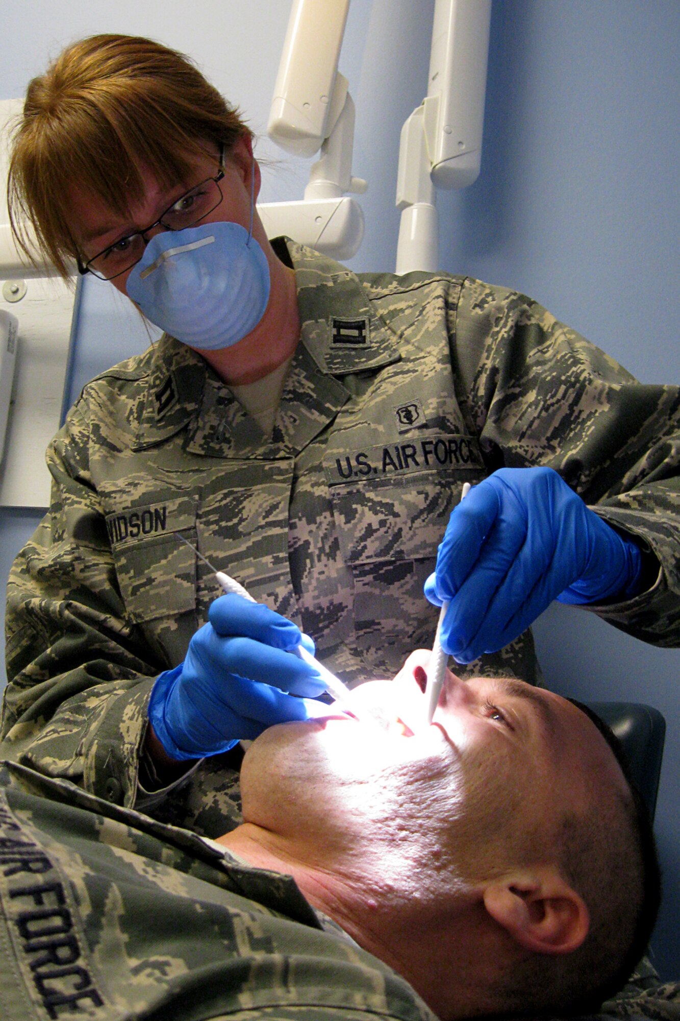 GRISSOM AIR RESERVE BASE, Ind. -- Capt. (Dr.) Madalyn Davidson examines the teeth of a 434th Air Refueling Wing Airman during his visit to the clinic here recently. Captain Davidson is one of three new dentists at Grissom. (U.S. Air Force photo illustration/Capt. Kelly Howard)                               
