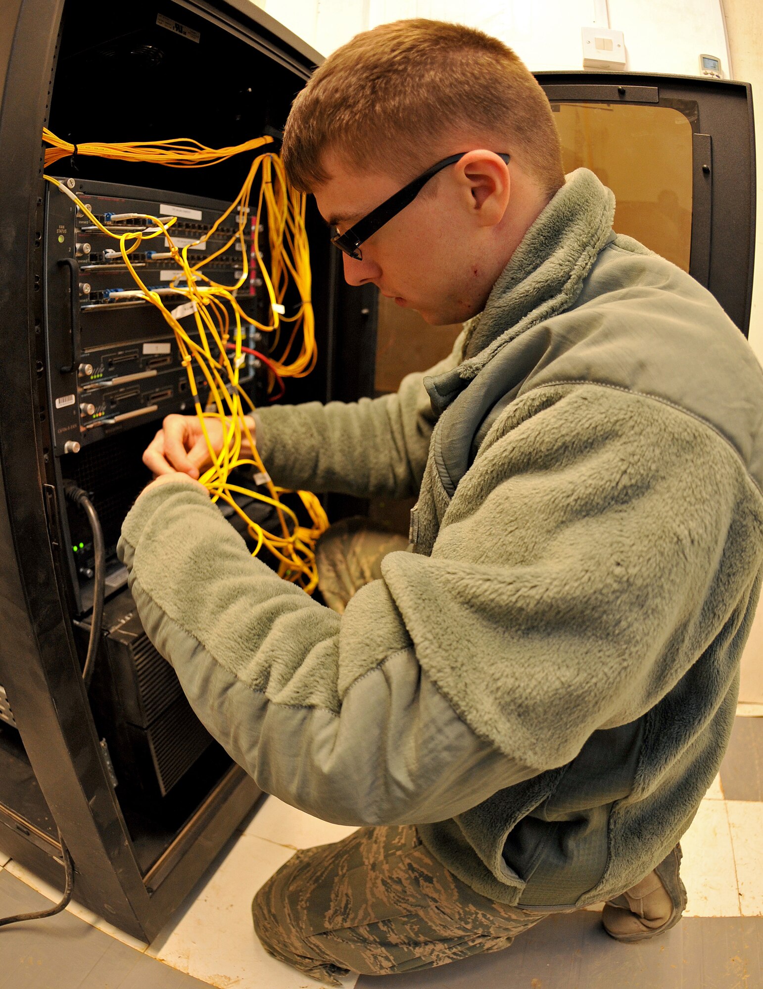 Senior Airman Raymond Harmon, Contingency Operating Base Speicher direct support signal team network administrator, reorganizes wires inside an area distribution node Jan. 20, 2011, on COB Speicher, Iraq. (U.S. Air Force photo by Senior Airman Andrew Lee/Released) 