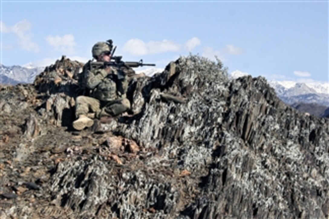U.S. Army Sgt. Nick Andrews looks into the valley from a mountaintop outside the village of Nengaresh, Nuristan province, Afghanistan, on Jan. 21, 2010.  Andrews is assigned to Company C, 1st Battalion, 133rd Infantry Regiment.  