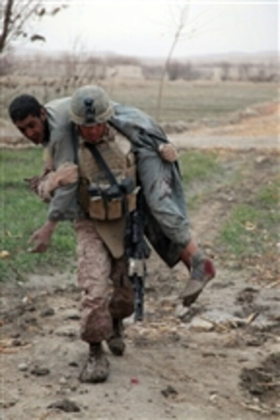 U.S. Marine Corps Cpl. Jose Aguilarmendez, a machine gun team leader with 1st Platoon, Kilo Company, 3rd Battalion, 5th Marine Regiment, Regimental Combat Team 2, carries an Afghan that was injured by an improvised explosive device during a security patrol in Sangin district, Helmand province, Afghanistan, on Jan. 12, 2011.  Marines conducted security patrols to decrease insurgency and gain the trust of the local population.  The battalion was one of the combat elements of Regimental Combat Team 2, which conducted counterinsurgency operations in partnership with the International Security Assistance Forces.  