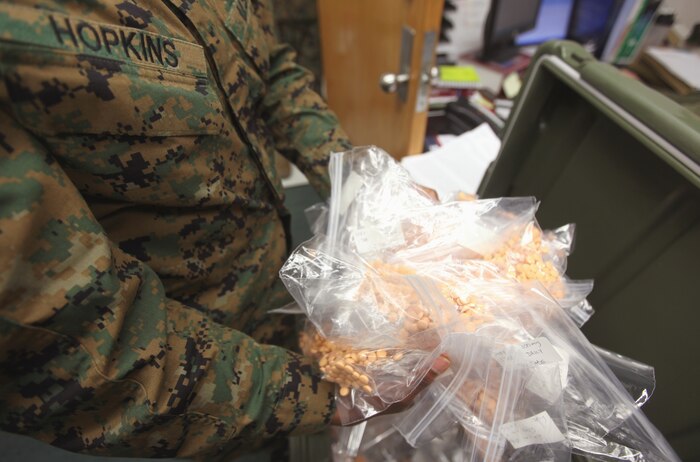 Petty Officer 2nd Class Yeishia R. Hopkins, a corpsman with the Combined Aid Station, 2nd Marine Logistics Group (Forward), picks up shows the amount of pills that will be distributed to the Marines and sailors of the Group prior to their deployment aboard Camp Lejeune, N.C., Jan. 26, 2010.  The corpsmen at the CAS have the arduous task of keeping track of medical records, making sure the Marines and sailors are up to date with their vaccines and ensuring the Group is ready to deploy.  (U.S. Marine Corps photo by Lance Cpl. Bruno J. Bego)
