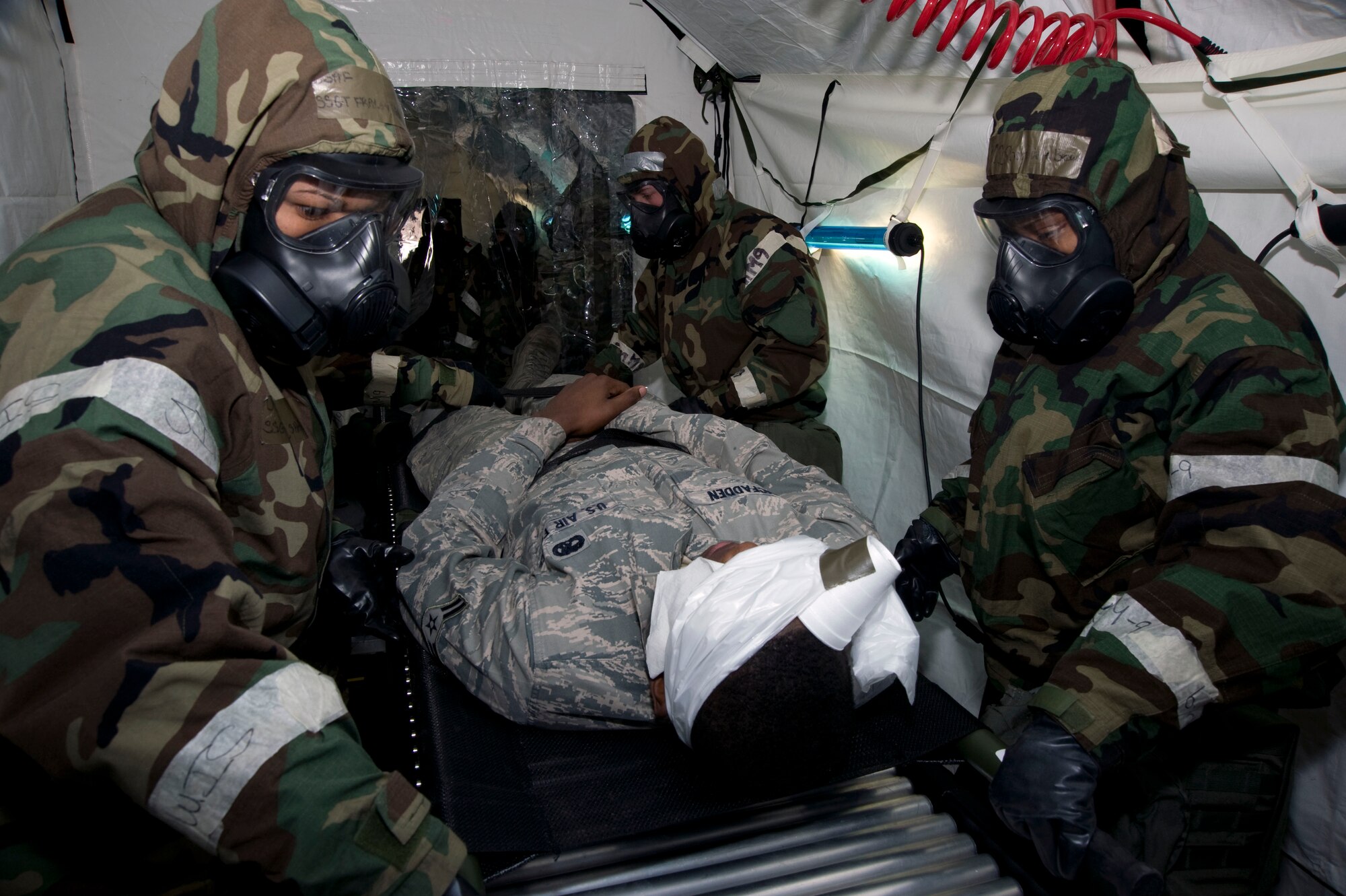 U.S Air Force medics from the 35th Medical Group simulate decontaminating an injured patient during a mock chemical attack Jan. 27, 2011, at Misawa Air Base, Japan. Misawa Airmen practiced responding to chemical warfare as part of an operational exercise. (U.S. Air Force photo by Tech. Sgt. Russell McBride/Released)