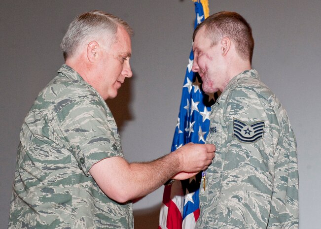 NELLIS AIR FORCE BASE, Nev.-- Col. Kevin Fox, 99th Mission Support Group commander, presents the Purple Heart to Tech. Sgt. Cory Kemp, 99th Civil Engineer Squadron explosive ordnance disposal technician, for his honorable service during Operation Enduring Freedom. Sergeant Kemp sustained injuries from an improvised explosive device detonation in Kandahar, Afghanistan, in September. The Purple Heart is awarded to members of the U.S. military who are wounded by an enemy during combat operations. (U.S. Air Force photo by Airman 1st Class Jamie Nicley)