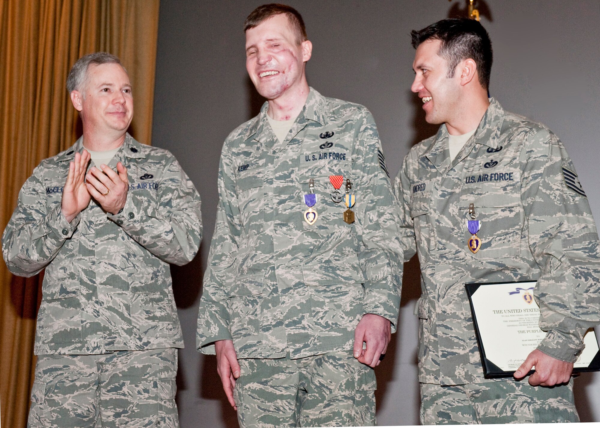 NELLIS AIR FORCE BASE, Nev.-- Lt. Col. Mark McCloud, 99th Civil Engineer Squadron commander, congratulates Tech. Sergeants Cory Kemp and Jermaine Kindred, 99th Civil Engineer Squadron explosive ordnance disposal technicians during a decoration ceremony Jan. 26.  Both sergeants received Purple Hearts after sustaining injuries from an improvised explosive device detonation in Kandahar, Afghanistan, in September.  Sergeant Kemp also received an Air Force Combat Action Medal for his service during Operation Enduring Freedom. The Purple Heart is awarded to members of the U.S. military who are wounded by an enemy during combat operations. The Combat Action Medal is awarded to Airmen who have been involved in direct fighting situations where they risked their lives in an enemy engagement. (U.S. Air Force photo by Airman 1st Class Jamie Nicley)

