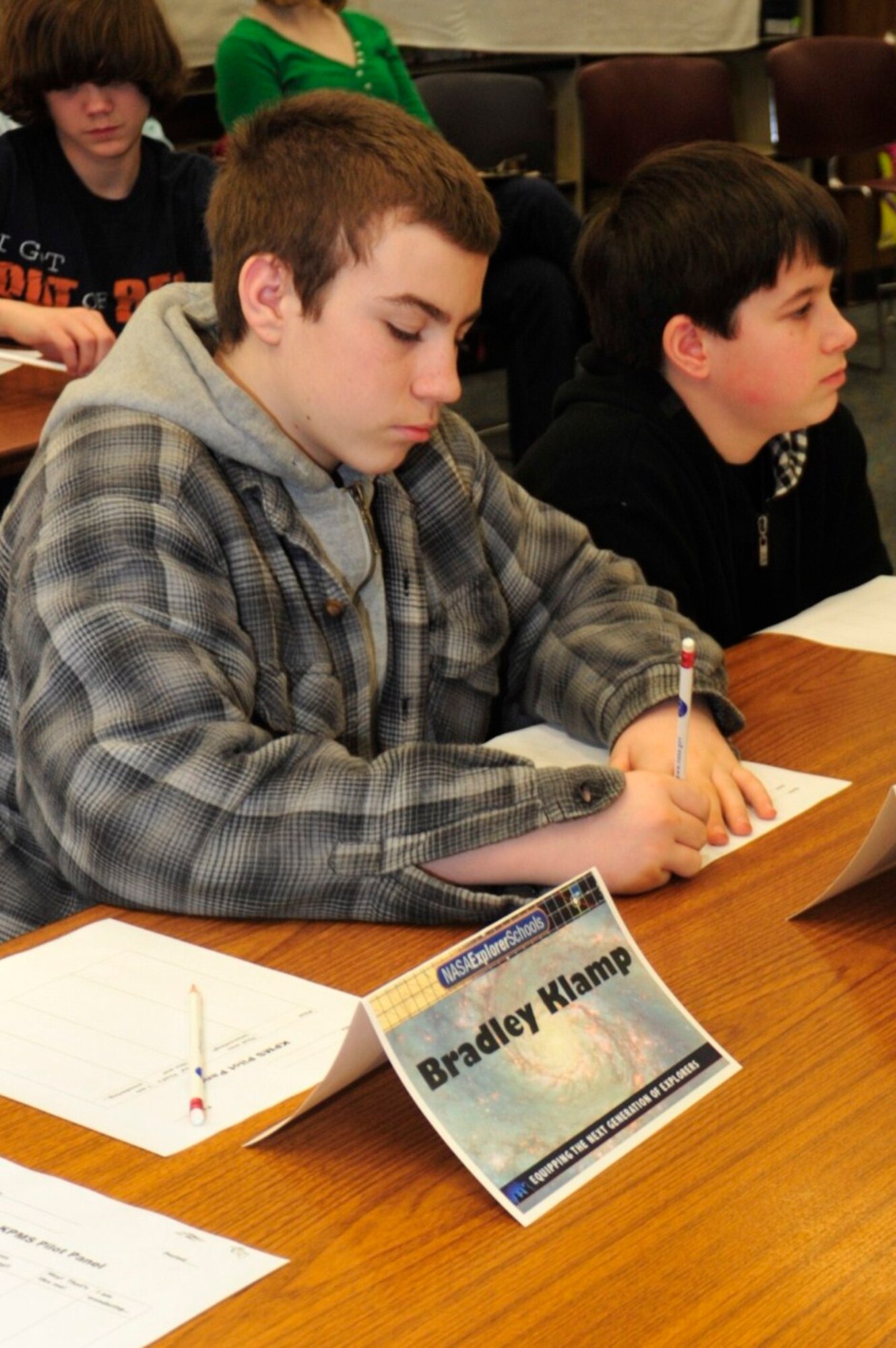 While listening to the pilot panel speak, River Absten, 12, a seventh grade Key Peninsula Middle School student, writes down additional questions to ask Jan. 24 in Lakebay, Wash. River asked one of the  McChord Field 10th Airlift Squadron pilots, “Did you always want to fly airplanes?” (U.S. Air Force photo/Airman Leah Young)