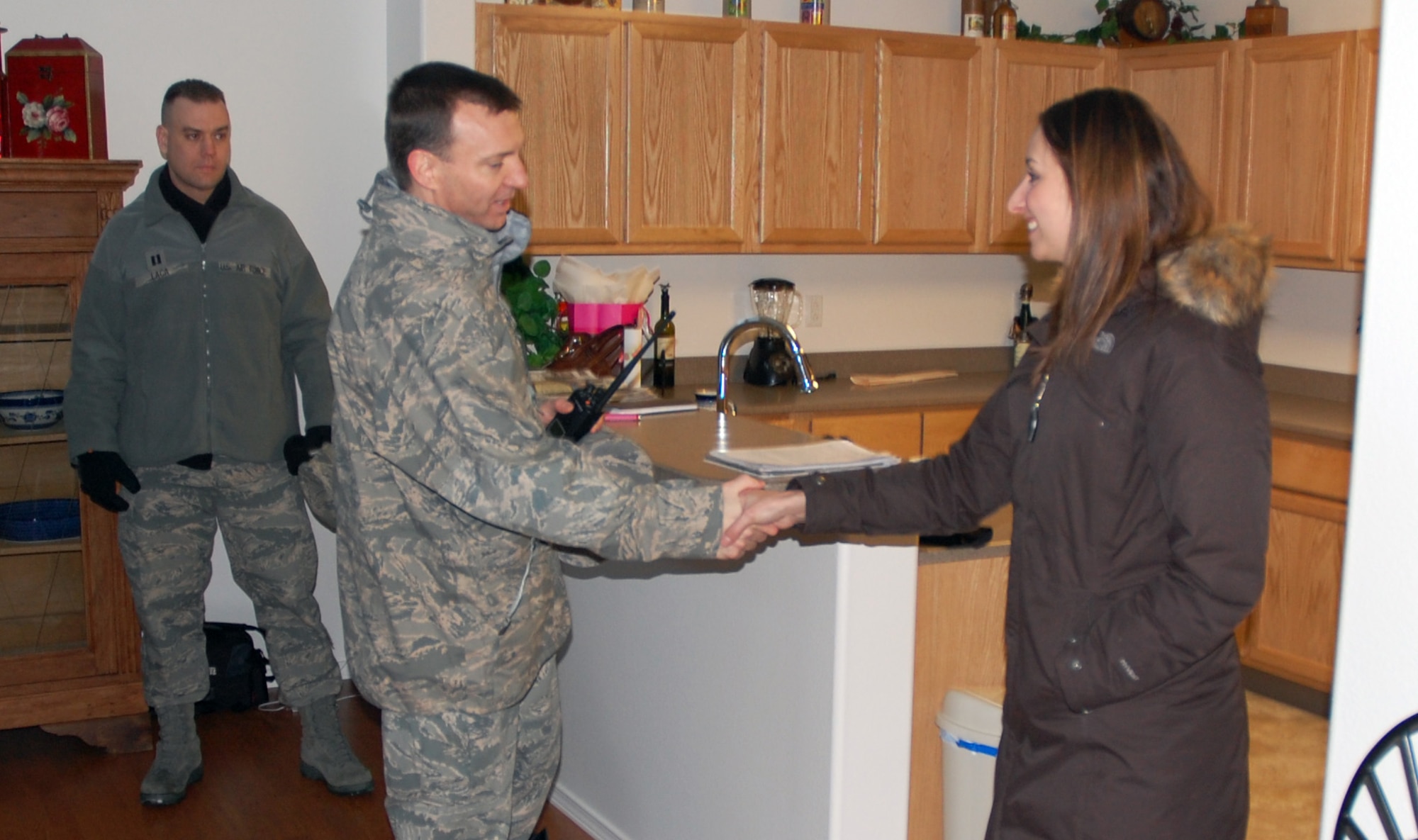 Col. Lynn Scheel meets with Capt. Max and Lori Cover following a ribbon cutting ceremony at their residence in Ravens Wood neighborhood Jan. 18, 2011, Eielson Air Force Base, Alaska.  The new company-grade officer housing area will add 29 new homes to the base's housing inventory. Colonel Scheel is the 354th Fighter Wing vice commander. (U.S. Air Force Photo/Tech. Sgt. Shad Eidson)