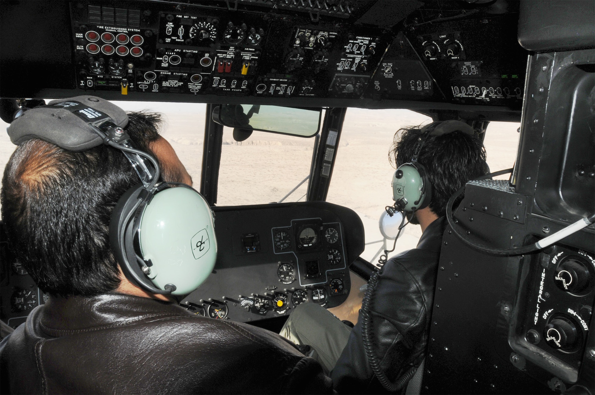 Afghan air force 1st Lt. Abdul Saboor Amin looks on as Afghan air force 1st Lt. Ahmad Fawad Haidari practices traffic patterns during a training exercise Jan. 24, 2011, outside of Kabul. (U.S. Navy photo/Petty Officer 2nd Class Vladimir Potapenko)