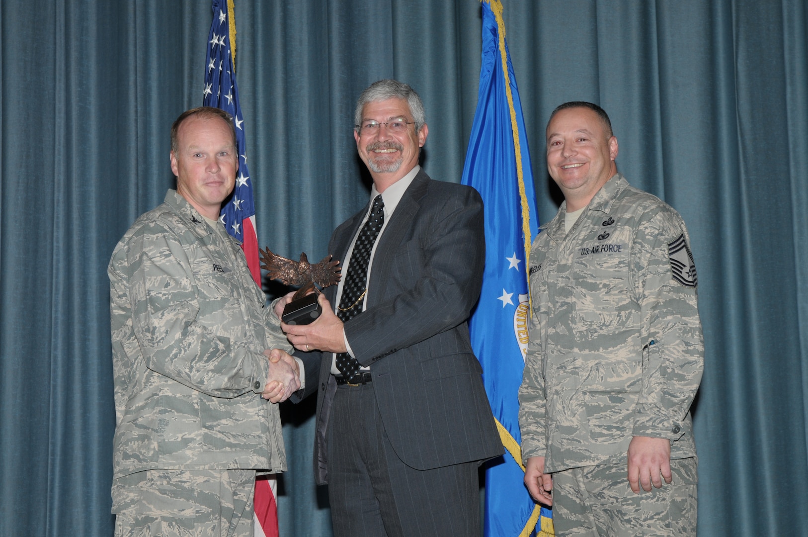 Col. Scott Peel, 902nd Mission Support Group commander, and Chief Master Sgt. Jesus Mireles III, 902nd MSG superintendent, present William Stewart, Air Force Personnel Center, with the award for Civilian Supervisor during the Joint Base San Antonio Randolph 4th Quarter Award Ceremony at Randolph Air Force Base, Texas, Jan. 26. (U.S. Air Force photo/Joel Martinez)