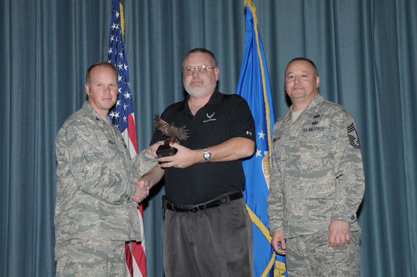 Col. Scott Peel, 902nd Mission Support Group commander, and Chief Master Sgt. Jesus Mireles III, 902nd MSG superintendent, present Frank Radis with the award for Civilian Non-Supervisory Category III, during the Joint Base San Antonio Randolph 4th Quarter Award Ceremony at Randolph Air Force Base, Texas, Jan. 26. (U.S. Air Force photo/Joel Martinez)