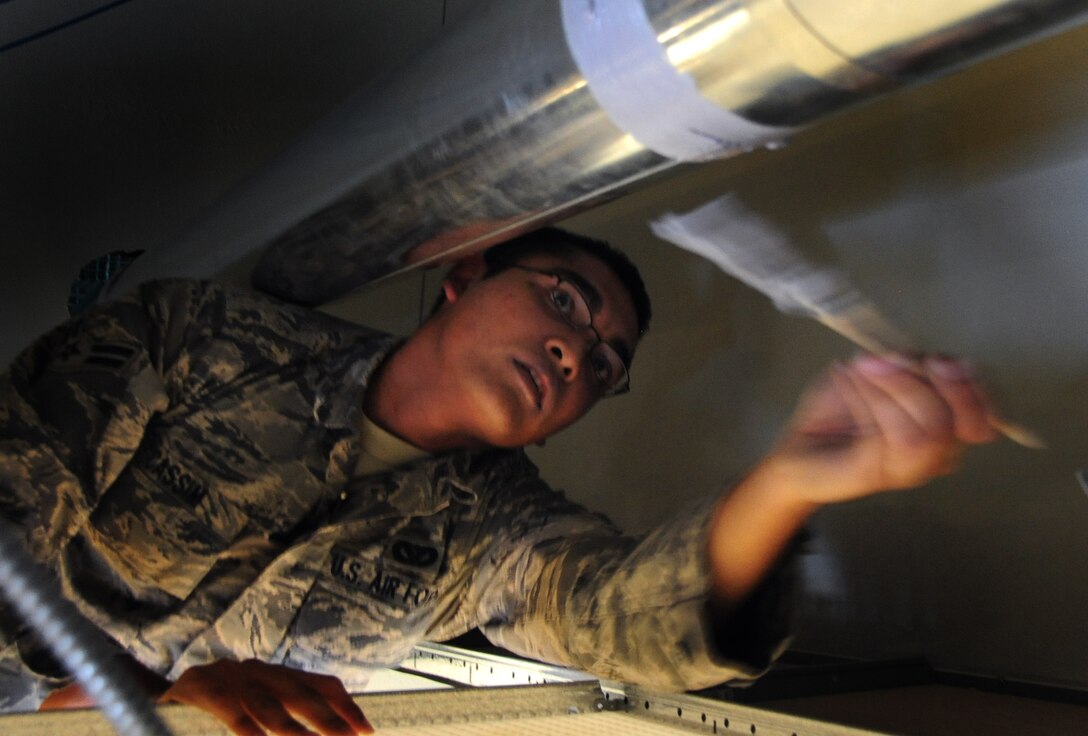 Airman 1st Class Mohamed Cassim, 28th Civil Engineer Squadron heating, ventilation and air conditioning journeyman, brushes sealant around a new heating vent at Ellsworth Air Force Base, S.D., Jan. 26, 2011.  The Air Force saved more than $75,000 by having the Airmen from 28th CES install the new HVAC system rather than contractors. (U.S. Air Force photo/Senior Airman Anthony Sanchelli)
