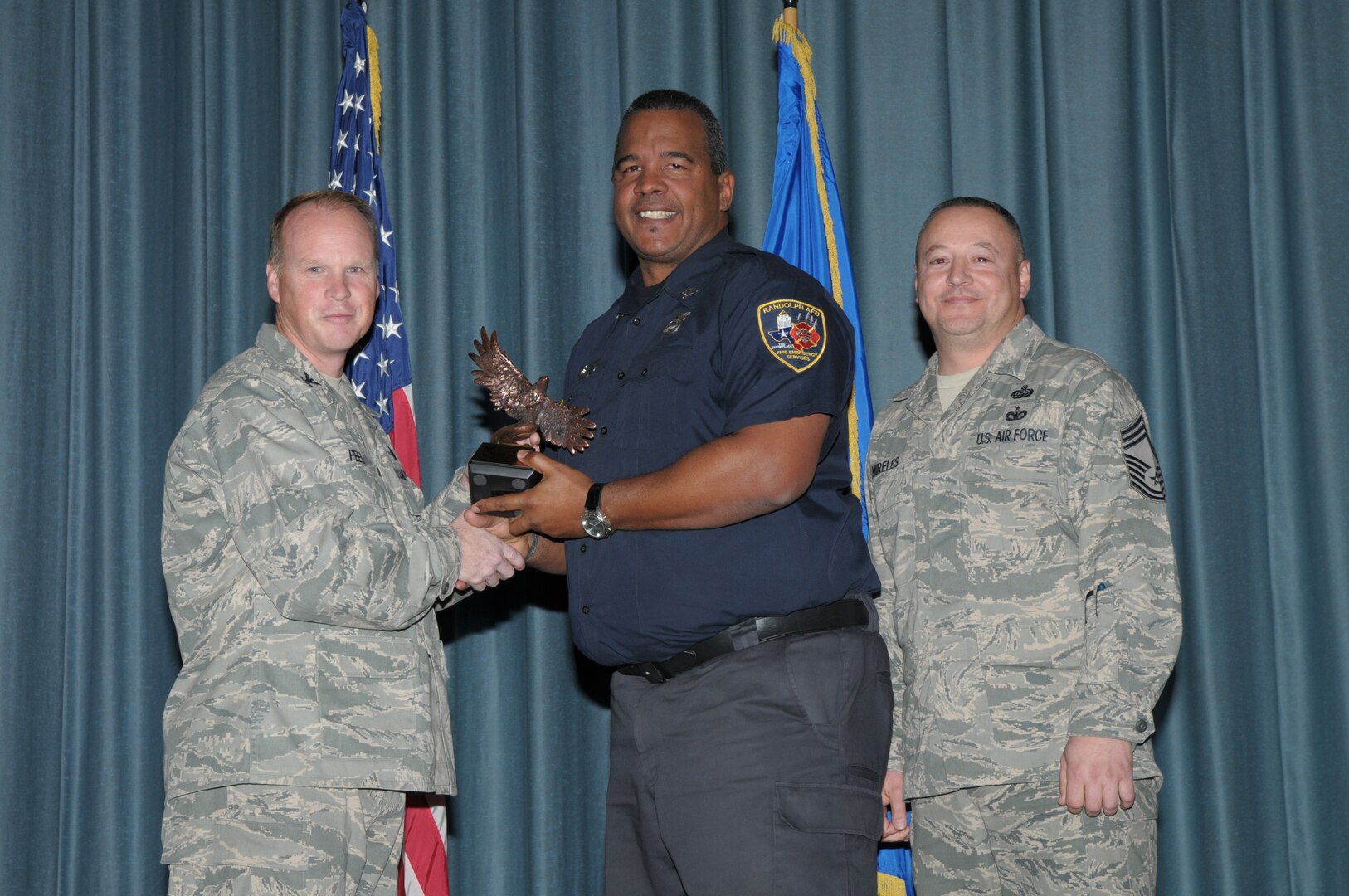 Col. Scott Peel, 902nd Mission Support Group commander, and Chief Master Sgt. Jesus Mireles III, 902nd MSG superintendent, present Ronald Price, 902nd Civil Engineer Squadron, with the award for Civilian Non-Supervisor Category I, during the Joint Base San Antonio Randolph 4th Quarter Award Ceremony at Randolph Air Force Base, Texas, Jan. 26. (U.S. Air Force photo/Joel Martinez)