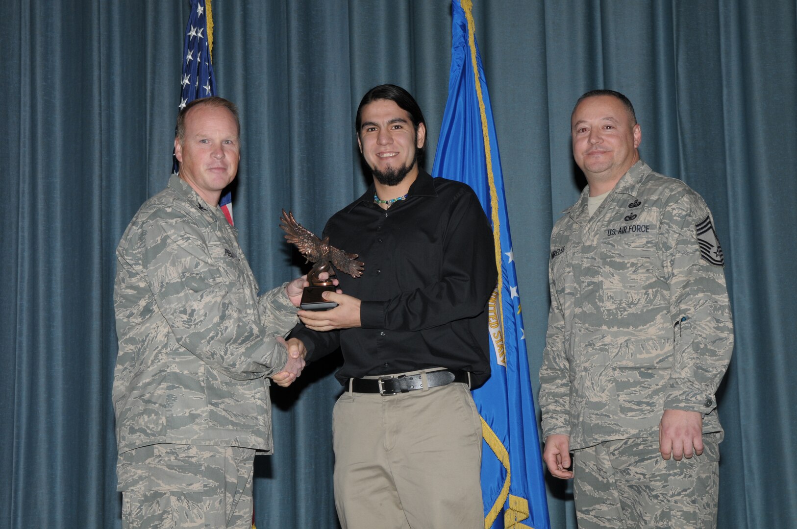 Col. Scott Peel, 902nd Mission Support Group commander, and Chief Master Sgt. Jesus Mireles III, 902nd MSG superintendent, present Brian Gastelum with the award for the Civilian Non-Appropriated Fund category, during the Joint Base San Antonio Randolph 4th Quarter Award Ceremony at Randolph Air Force Base, Texas, Jan. 26.(U.S. Air Force photo/Joel Martinez)