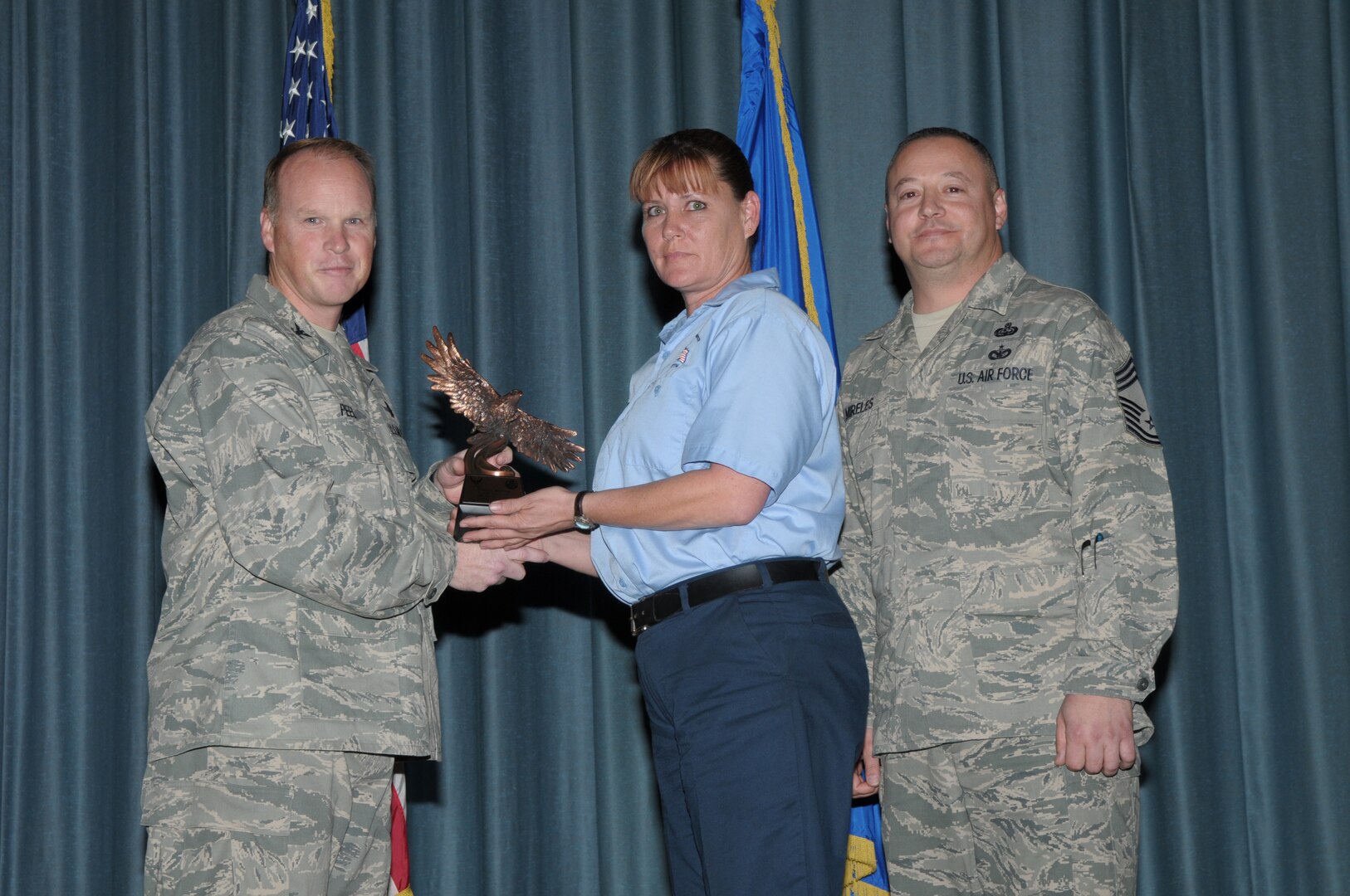 Col. Scott Peel, 902nd Mission Support Group commander, and Chief Master Sgt. Jesus Mireles III, 902nd MSG superintendent, present Tammy Bishop, 12th Flying Training Wing, with the award for the Civilian Wage Grade category, during the Joint Base San Antonio Randolph 4th Quarter Award Ceremony at Randolph Air Force Base, Texas, Jan. 26. (U.S. Air Force photo/Joel Martinez)