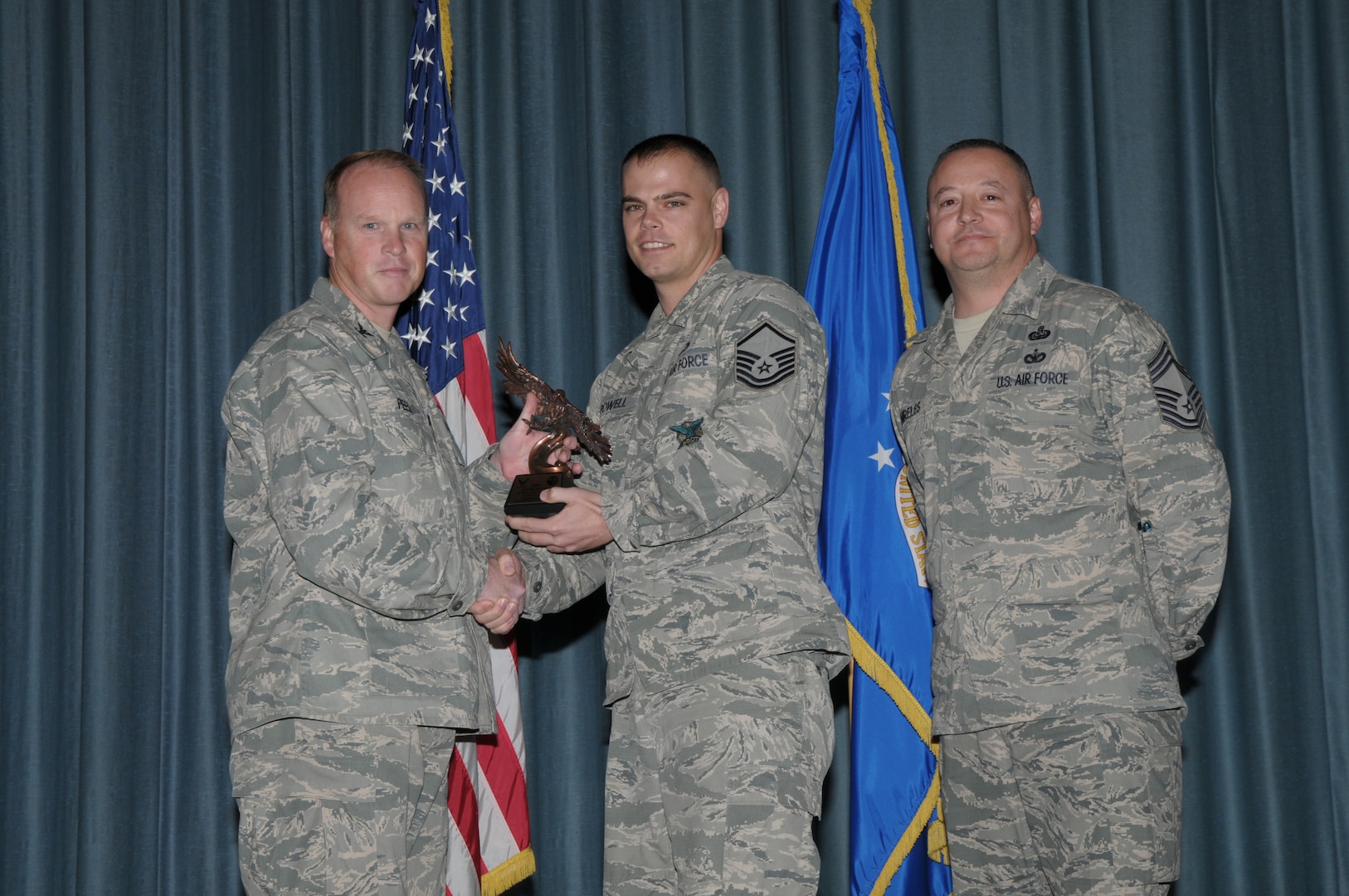 Col. Scott Peel, 902nd Mission Support Group commander, and Chief Master Sgt. Jesus Mireles III, 902nd MSG superintendent, present Master Sgt. Jeremy Powell, 902nd Civil Engineer Squadron, with the award for the Senior NCO category, during the Joint Base San Antonio Randolph 4th Quarter Award Ceremony at Randolph Air Force Base, Texas, Jan. 26.  (U.S. Air Force photo/Joel Martinez)