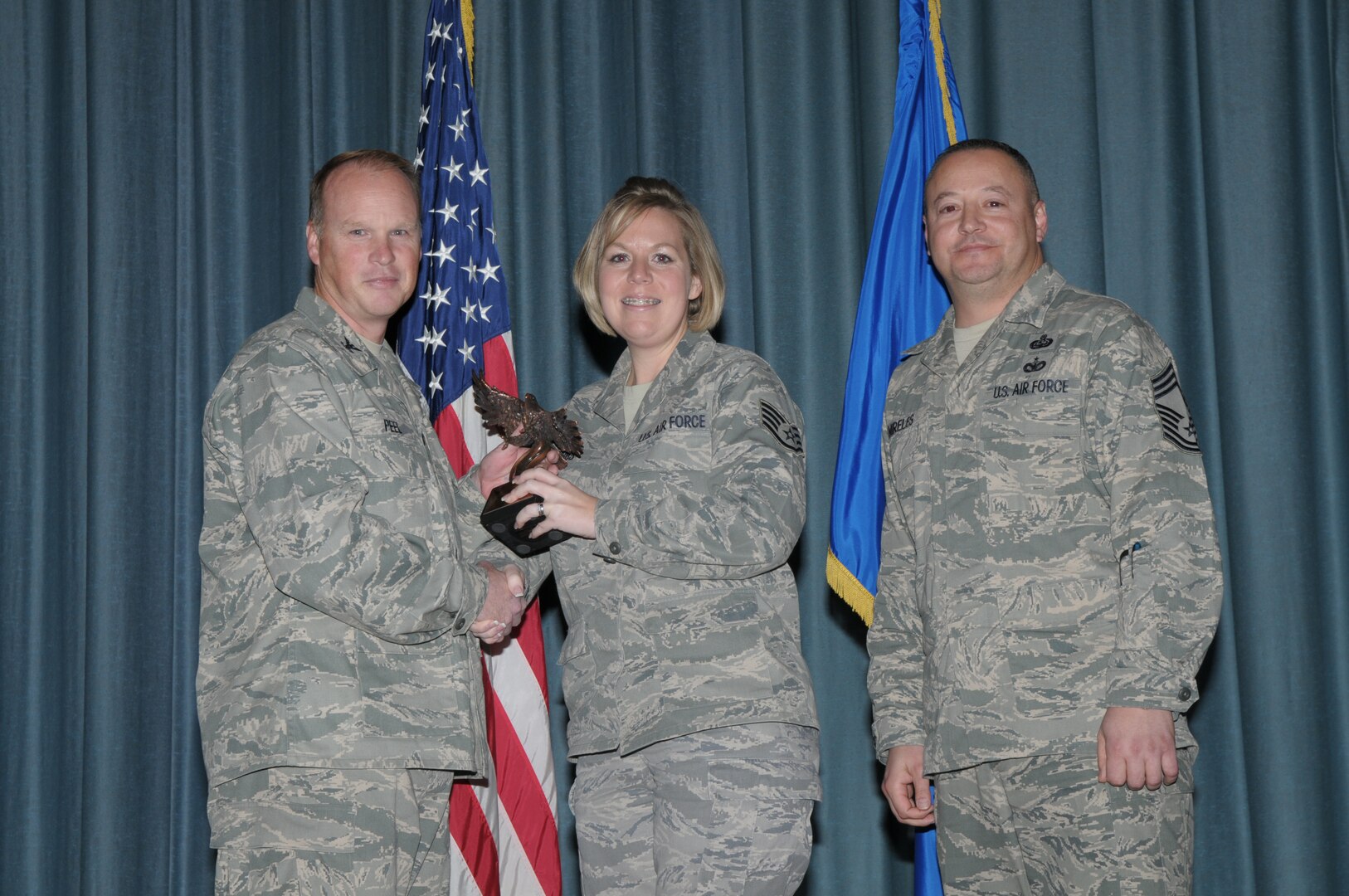 Col. Scott Peel, 902nd Mission Support Group commander, and Chief Master Sgt. Jesus Mireles III, 902nd MSG superintendent, present Staff Sgt. Rebecca Fobbs, Air Force Personnel Center, with the award for the Non-Commisioned Officer category, during the Joint Base San Antonio Randolph 4th Quarter Award Ceremony at Randolph Air Force Base, Texas, Jan. 26. (U.S. Air Force photo/Joel Martinez)