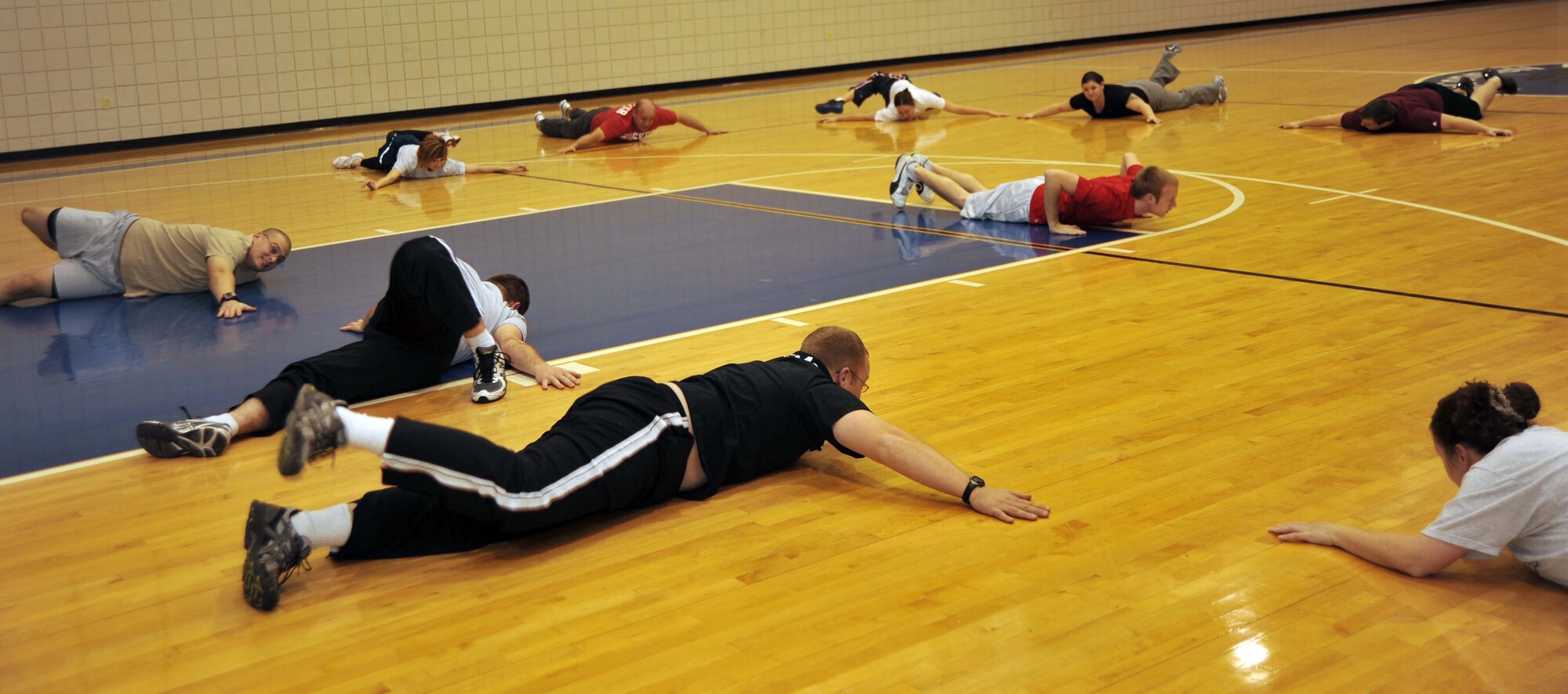 McConnell Airmen stretch their legs during the fitness center's Boot Camp class, Jan. 26, 2011, McConnell Air Force Base, Kan. To aid in their success, some "Biggest Loser" competitors are participating in the class.  The competition, which began Jan. 24, 2011, will last eight weeks, and includes 120 active duty Airmen of all ranks and squadrons.  (U.S. Air Force photo/Senior Airman Abigail Klein