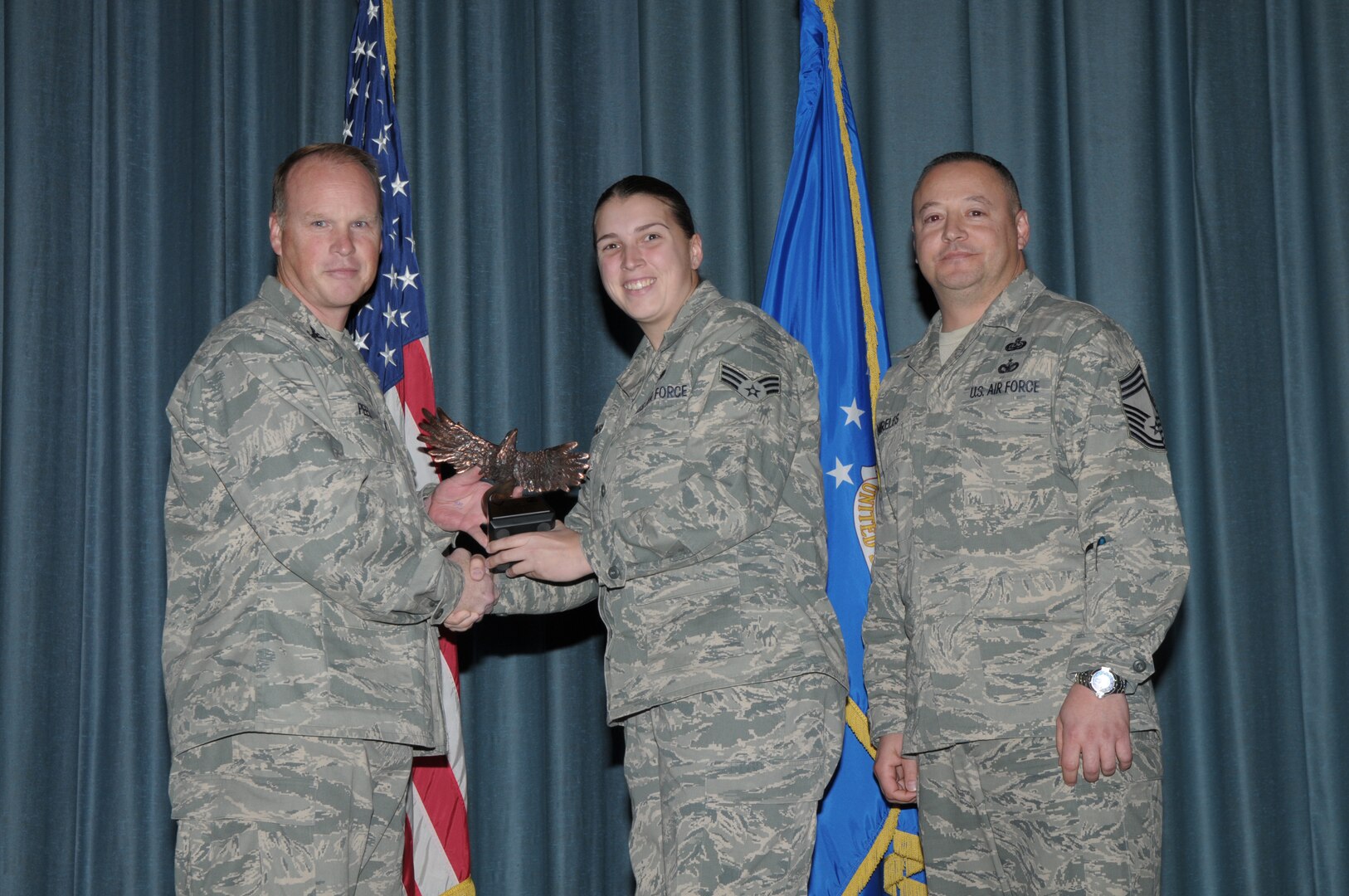 Col. Scott Peel, 902nd Mission Support Group commander, and Chief Master Sgt. Jesus Mireles III, 902nd MSG superintendent, present Senior Airman Shelly Kerstanski, Air Force Personnel Center, with the award for the Airman category, during the Joint Base San Antonio Randolph 4th Quarter Award Ceremony at Randolph Air Force Base, Texas, Jan. 26. (U.S. Air Force photo/Joel Martinez)