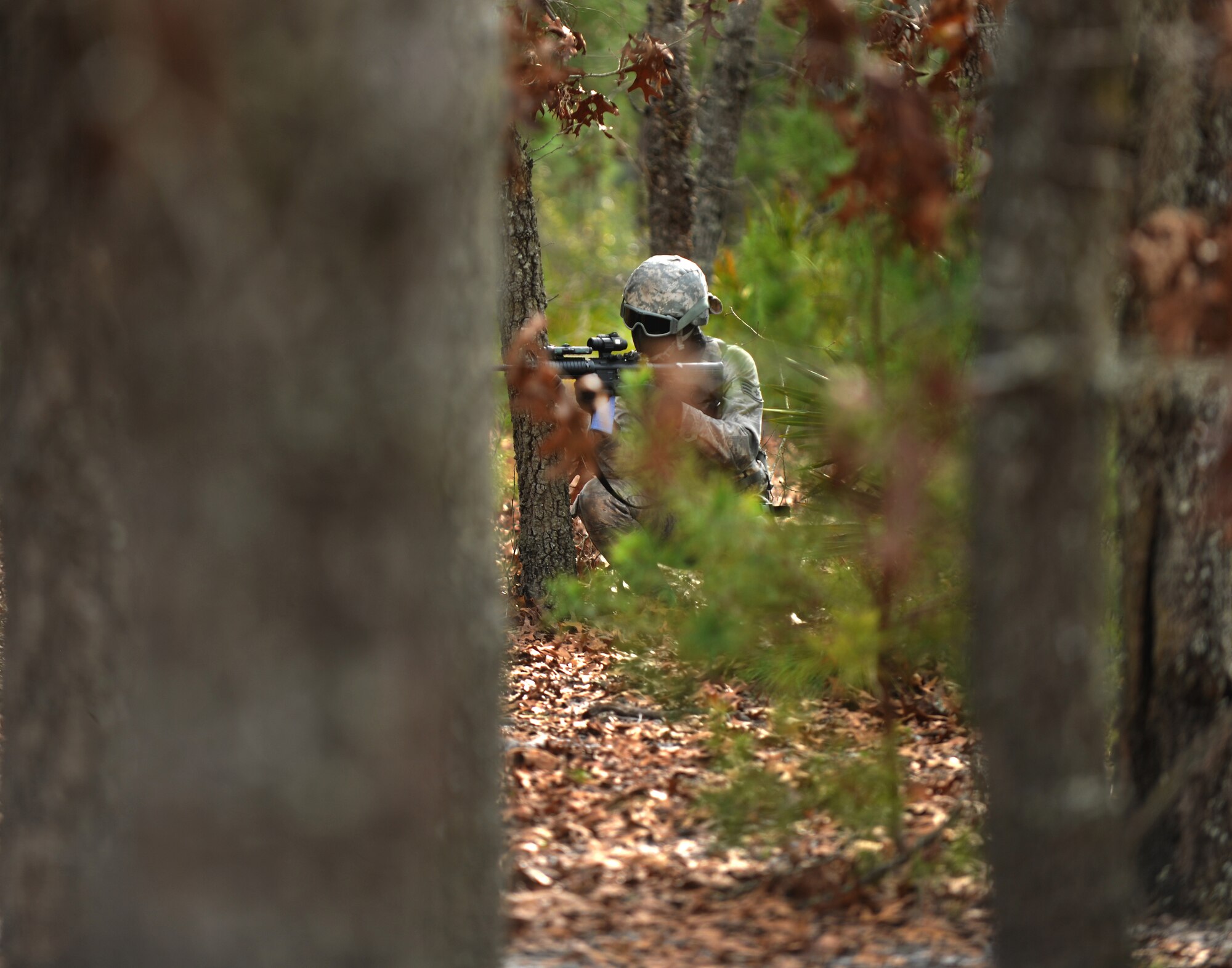 CAMP BLANDING, Fla.-- Staff Sgt. Ben Clark, 3rd Weather Squadron battlefield weather Airman at Fort Hood, Texas, ducks behind a tree during a ground combat training course Jan. 24. The course is designed to train battlefield weather Airmen on warrior task and battle drills, the basic skills that an Army infantry solider must have. (U.S. Air Force photo/Airman 1st Class Joshua Green)(RELEASED)
