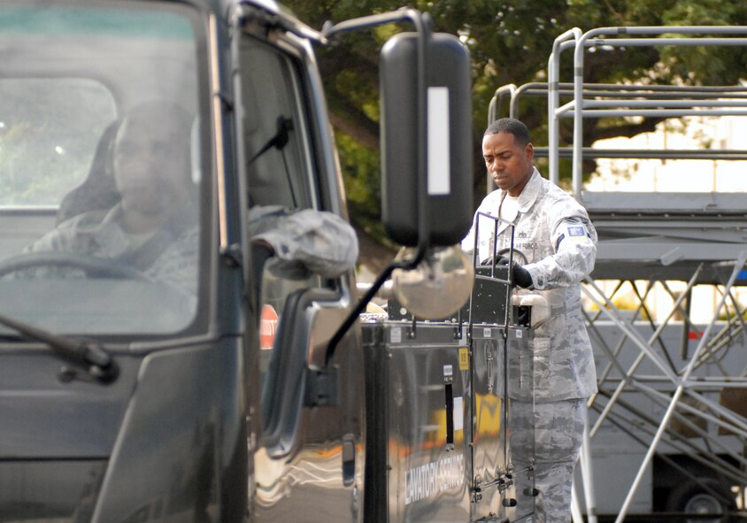 Tech. Sgt. Dwayne Johnson, a 735th Air Mobility Squadron air transportation specialist, prepares a lavatory truck to service Air Force One on the flight line at Joint Base Pearl Harbor-Hickam, Hawaii, Dec. 29, 2010. In his off-duty time, Sergeant Johnson started Operation iRide, a fund raiser which enabled all of the Airmen E-4 and below in his unit to attend their holiday party free. During the course of one month, Sergeant Johnson biked 1,000 miles and raised $2,020. (U.S. Air Force photo/Staff Sgt. Carolyn Viss)