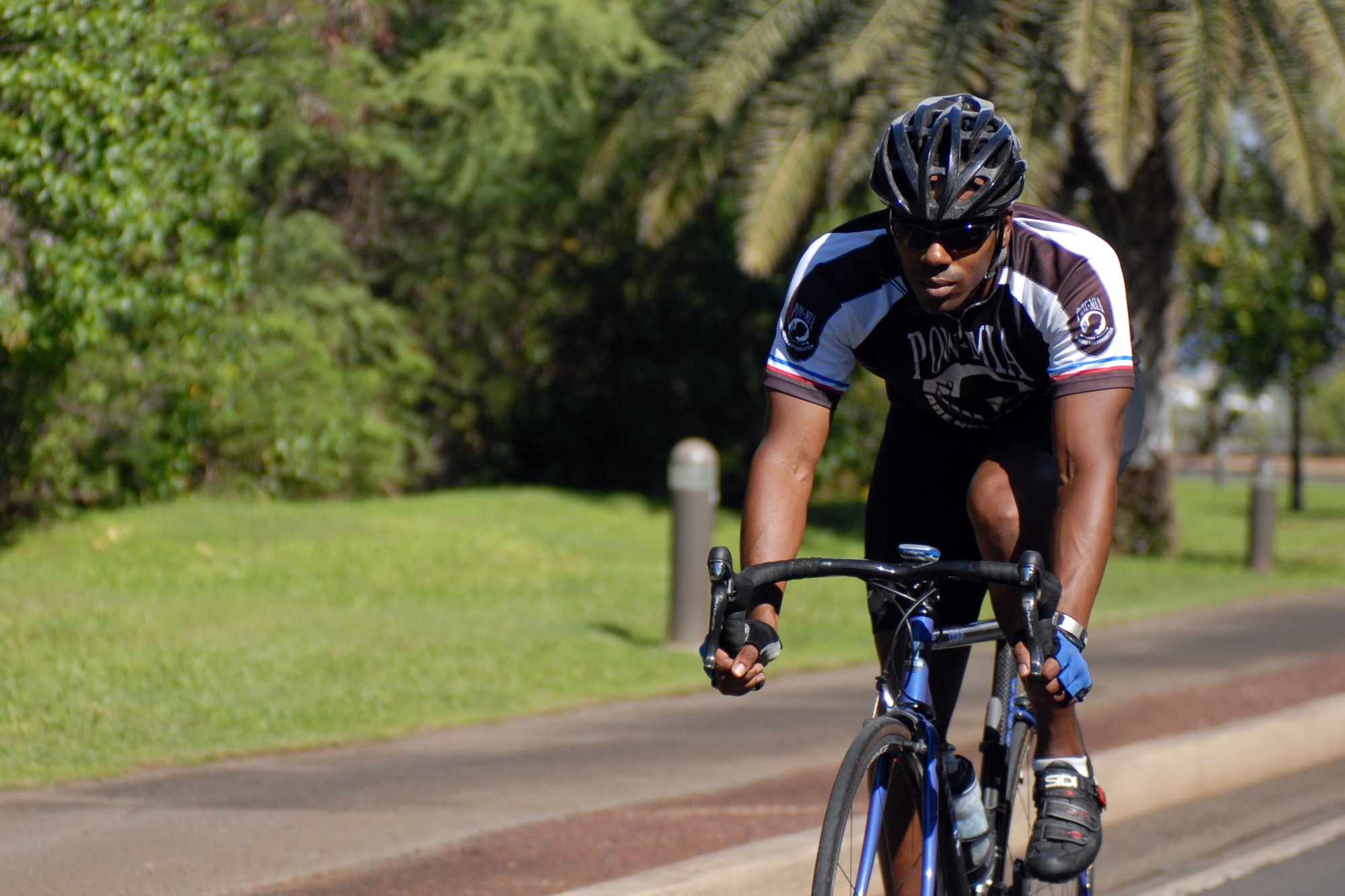 Tech. Sgt. Dwayne Johnson, a 735th Air Mobility Squadron air transportation specialist, rides along the path to Hickam Harbor at Joint Base Pearl Harbor-Hickam, Hawaii, Dec. 22, 2010. His love of cycling inspired him to start Operation iRide, a fund raiser which enabled all of the Airmen E-4 and below in his unit to attend their holiday party free. During the course of one month, Sergeant Johnson biked 1,000 miles and raised $2,020. (U.S. Air Force photo/Staff Sgt. Carolyn Viss)