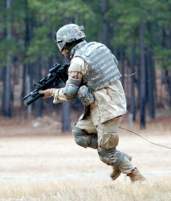 An Airman advances toward a hill during a live-fire exercise as part of Combat Skills Training for provincial reconstruction team members. In the exercise, teams of Airmen and Soldiers make their way up a hill while firing at targets using live ammunition. Airmen preparing for joint expeditionary taskings must be prepared for physically strenuous activities during their Army-led training courses. (U.S. Air Force photo/ Capt. John Severns)