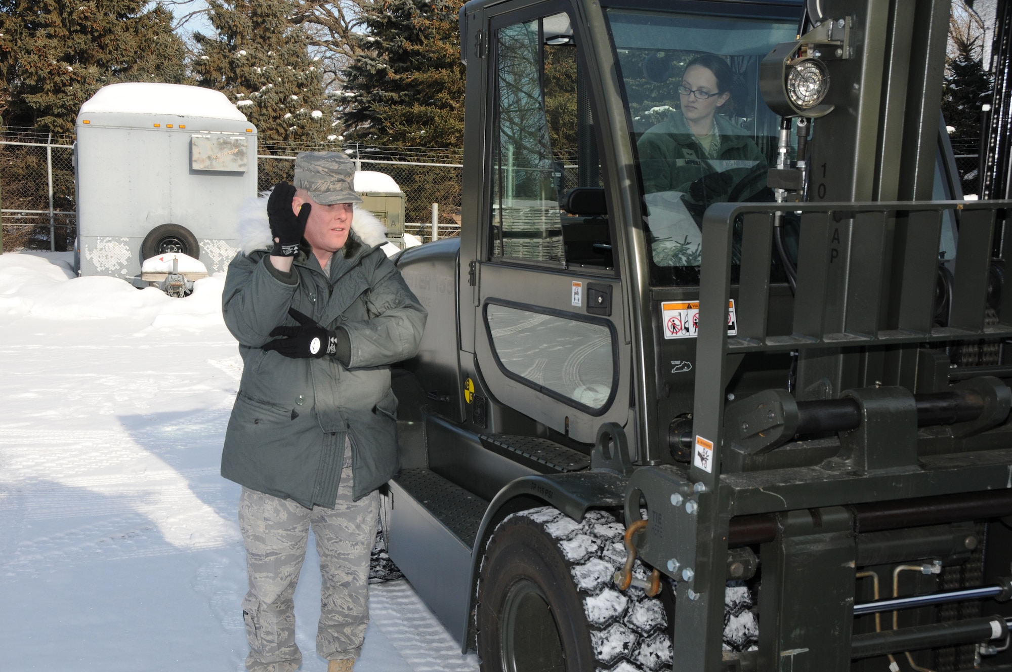 Master Sgt. John Kubes, superintendent of the small air terminal at the 133rd Logistics Readiness Squadron, directs a forklift driven by Senior Airman Kathryn Morrill of the small air terminal on Jan. 22, 2010 on the Air National Guard Base in St. Paul, Minn. Kubes has been selected to represent Minnesota as the Air Guard Outstanding Senior NCO and Morrill has been selected to represent Minnesota as the Air Guard Outstanding Airman for 2011. USAF official photo by Tech. Sgt. John Wiggins