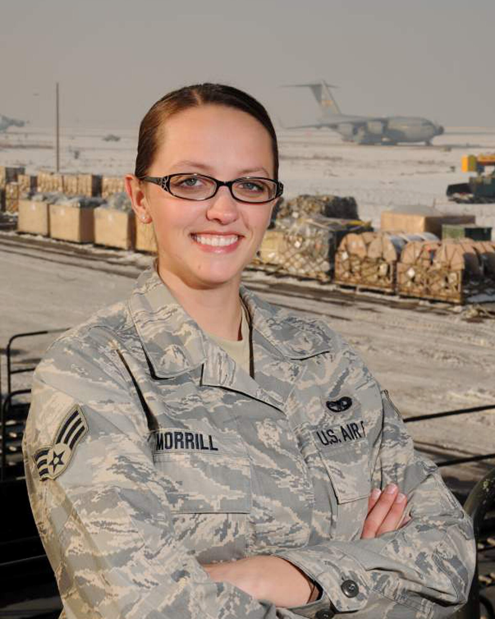 Senior Airman Kathryn Morrill of the small air terminal at the 133rd Logistics Readiness Squadron pauses near the flightline of a deployed location in November 2010 where she was working loading aircraft in support of Operation Enduring Freedom and Operation New Dawn. Morrill has been selected to represent Minnesota as the Air Guard Outstanding Airman for 2011.