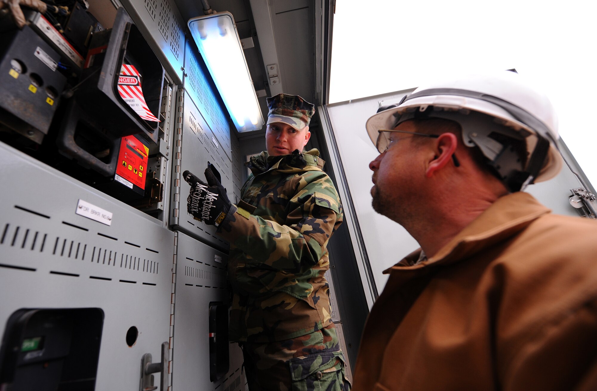 OFFUTT AIR FORCE BASE -- Navy Petty Officer 1st Class Adam Binon, a lead electrician with a Mobile Utilities Support Equipment team out of Port Hueneme, Calif., instructs Todd Osgood, 55th Civil Engineer Squadron, on how to operate the relay protection for the circuit breaker of the 2,500 KVA electrical substation outside the U.S. Strategic Command here. The MUSE team installed two substations for the facility after a water main broke outside the building Dec. 20, which caused electrical issues after water flooded the boiler room. U.S. Air Force photo by Josh Plueger (released)