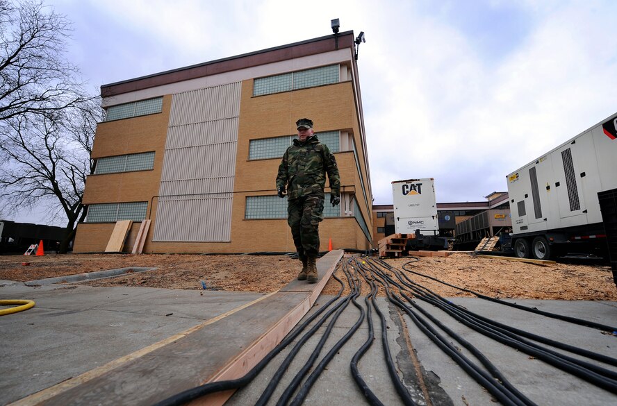 OFFUTT AIR FORCE BASE -- Navy Petty Officer 1st Class Adam Binon, a lead electrician with a Mobile Utilities Support Equipment team out of Port Hueneme, Calif., inspects the cables of a 2,500 KVA electrical substation outside the headquarters of U.S. Strategic Command here. The MUSE team recently installed two substations for the building after a water main broke outside the facility Dec. 20, which caused electrical issues after water flooded the boiler room. U.S. Air Force photo by Josh Plueger (released)