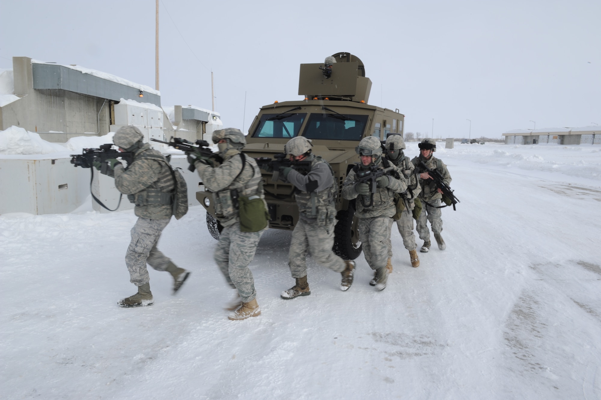MINOT AIR FORCE BASE, N.D. -- Airmen from the 5th Security Forces Squadron response force team advance towards a door during a training scenario at the weapons storage area here Jan. 24. Training like this helps the 5th SFS “Defenders” keep their combat skills sharp. (U.S. Air Force photo/Senior Airman Michael J. Veloz)