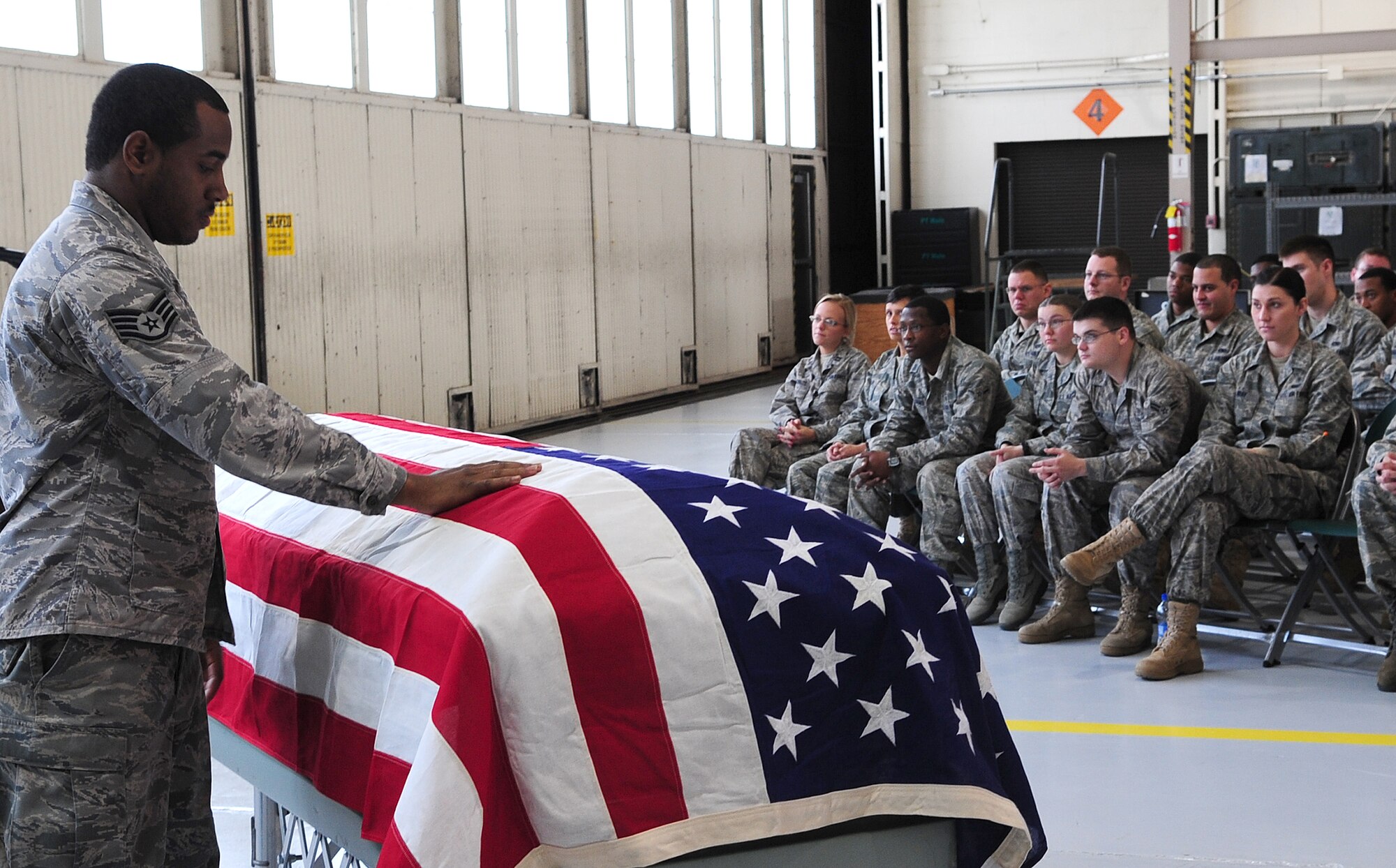 MOODY AIR FORCE BASE, Ga. -- Staff Sgt. Anthony Wilson, 723rd Aircraft Maintenance Squadron communications navigator craftsman, pays his respects to Senior Airman Larry Mitchell, 723rd Aircraft Maintenance Squadron communications navigator journeyman, during a mock memorial service. Sergeant Wilson and Airman Mitchell prepared a skit for the squadron’s safety briefing. (U.S. Air Force photo/Senior Airman Stephanie Mancha)(RELEASED)