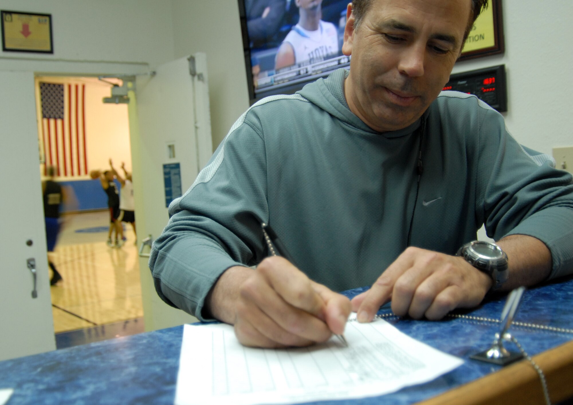 Retired Air Force Col. Chris Ultsch, Air Force Operational Test and Evaluation Center, Detachment 5 senior staff analyst, logs his daily mileage at the front desk of the Rosburg Fitness Center. Mr. Ultsch participates in the Run the Coast of California Incentive Program, running, walking and biking his way to 958 miles, the length of California’s coast. (Air Force photo by Kate Blais)